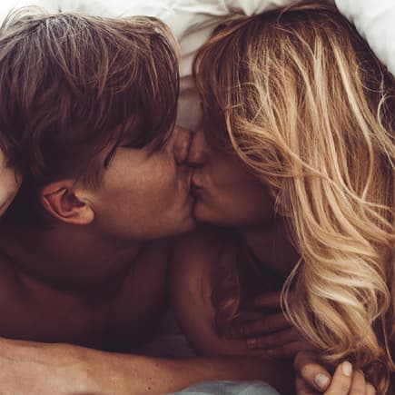 Ein Paar, das sich im Bett küsst. 