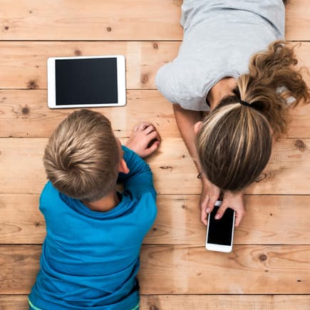 Zwei Kinder an mobilen Geräten.