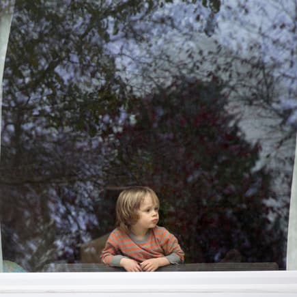 Ein kleiner Junge schaut aus dem Fenster.