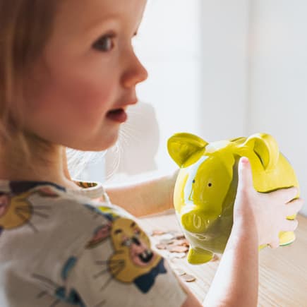 Ein kleines Mädchen mit Sparschwein