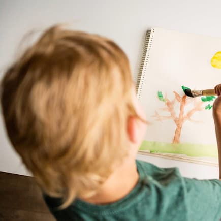 Kleiner Junge malt mit Tusche