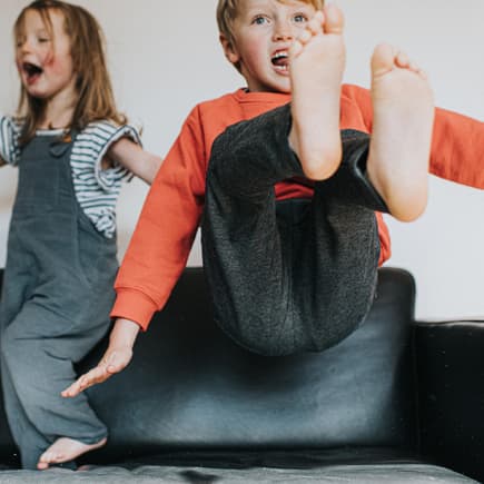 Zwei auf dem Sofa tobende Kinder