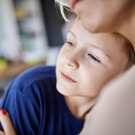 Ernster Sohn kuschelt mit Mutter.