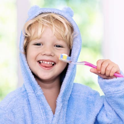 Niedliches Kind hält eine Zahnbürste mit Zahnpasta.