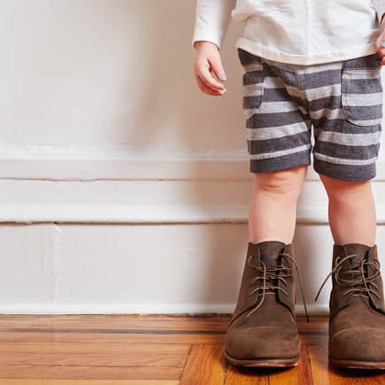 Kleinkind mit viel zu großen Schuhen.