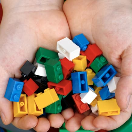 Kinderhände mit Legosteinen.
