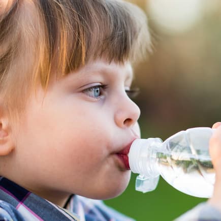 Mädchen trinkt aus einer Wasserflasche.