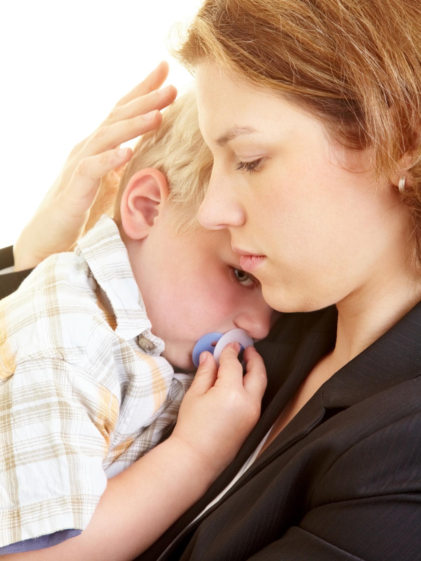 Ein trauriger Junge kuschelt sich an seine Mama.