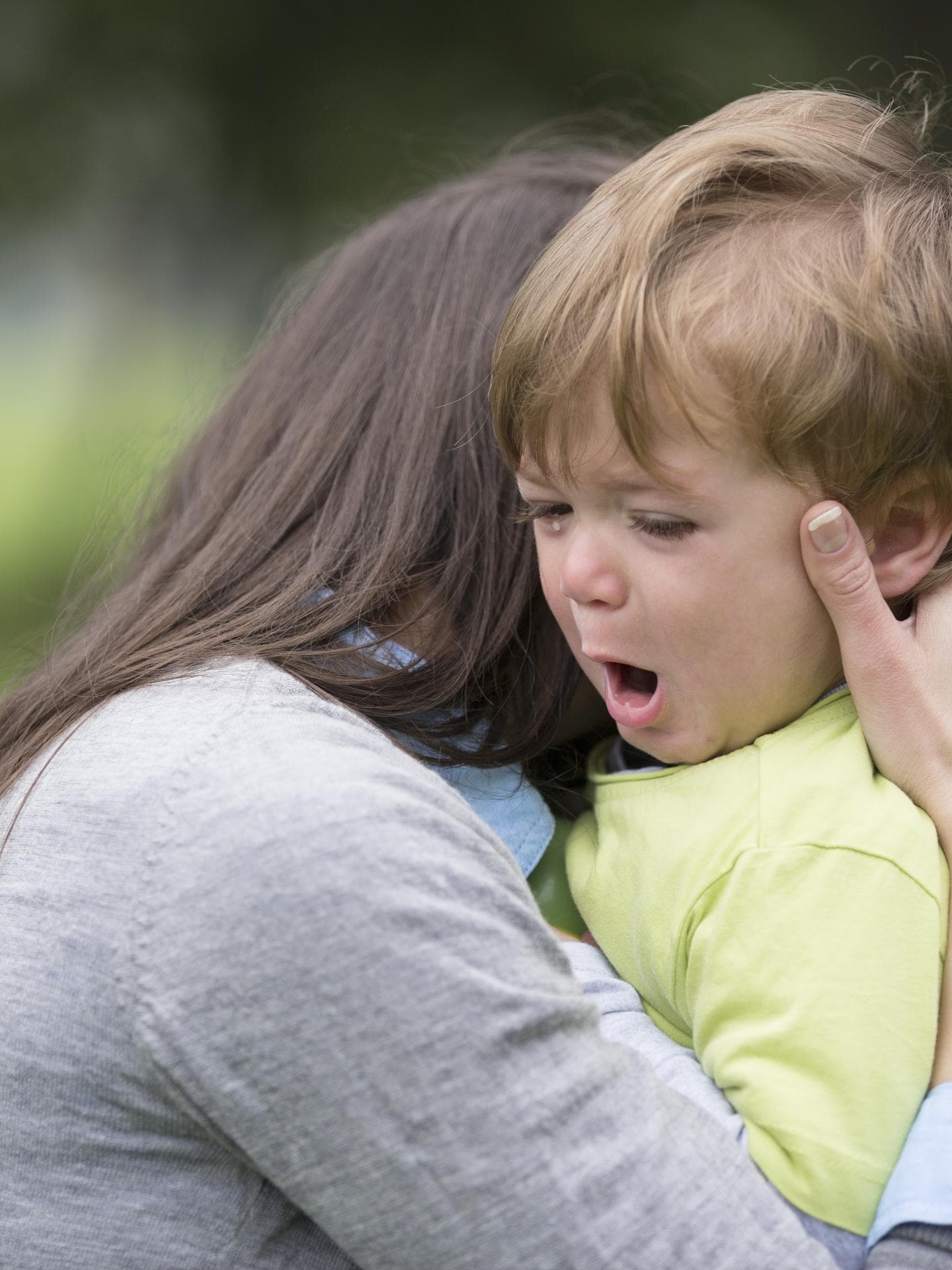 Ein kleiner Junge wird bei einem Wutanfall von seiner Mutter getröstet.