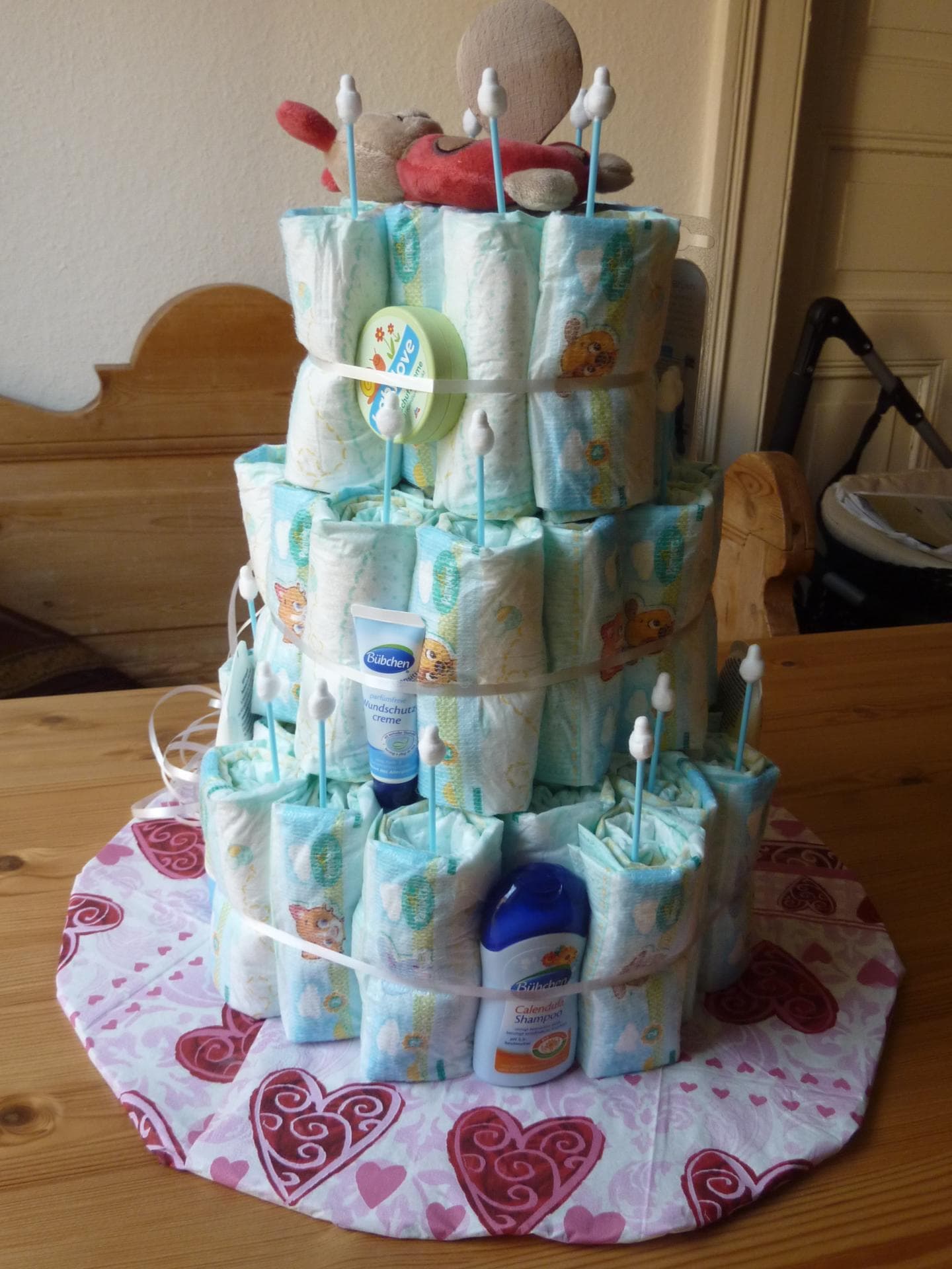 Eine Windeltorte mit "Kerzen" und kleinen Geschenken.