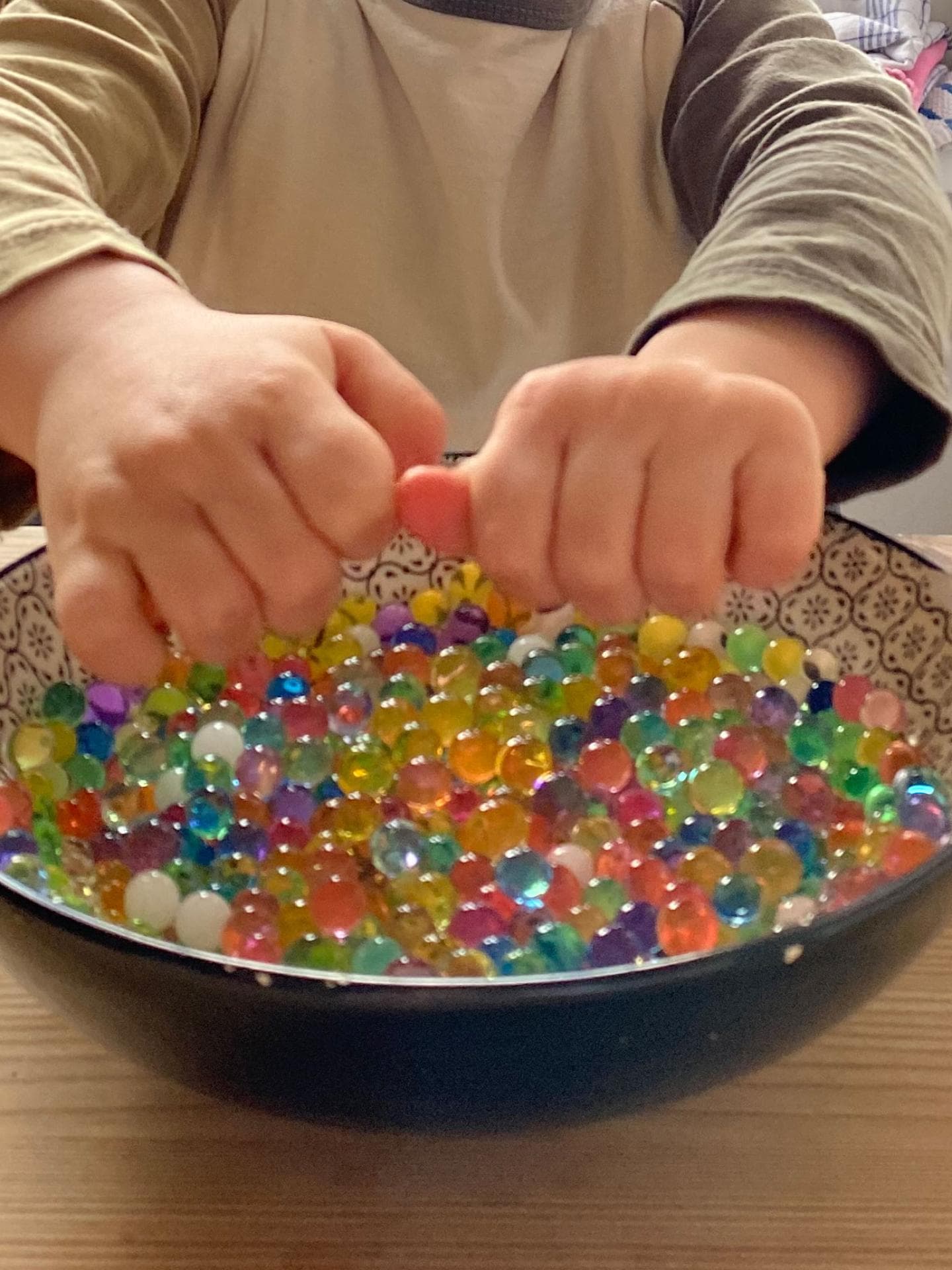 Ein kleiner Junge spielt mit Wasserperlen. 