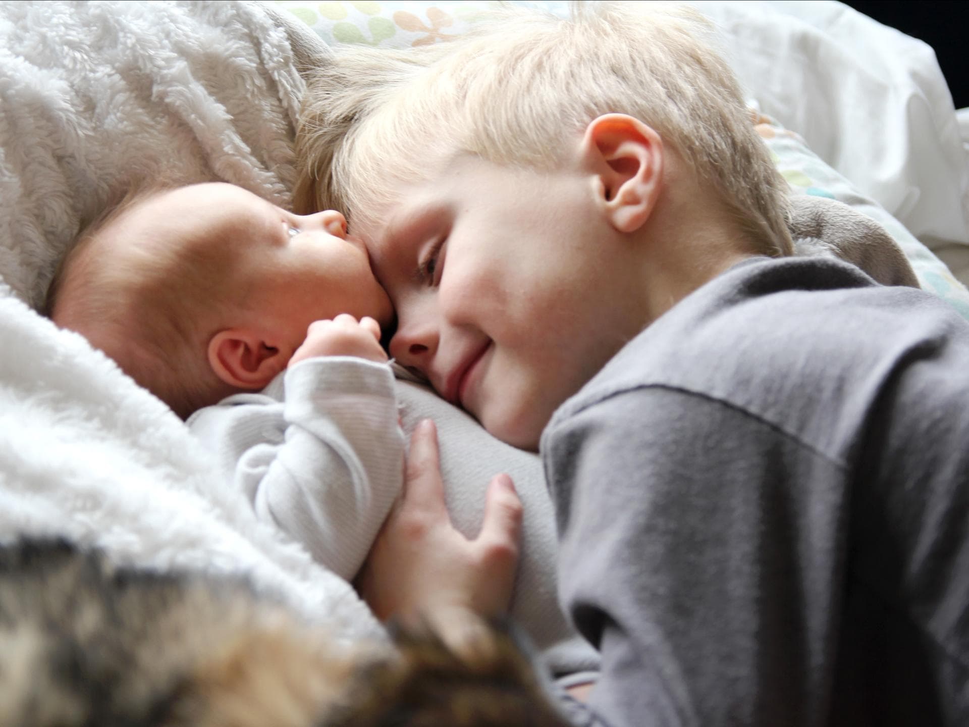 Junge kuschelt mit Baby Junge kuschelt mit Baby