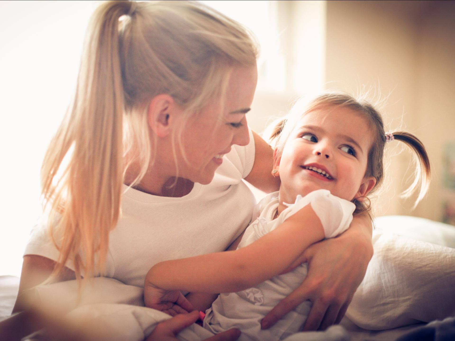 Mutter umarmt ihre kleine Tochter
