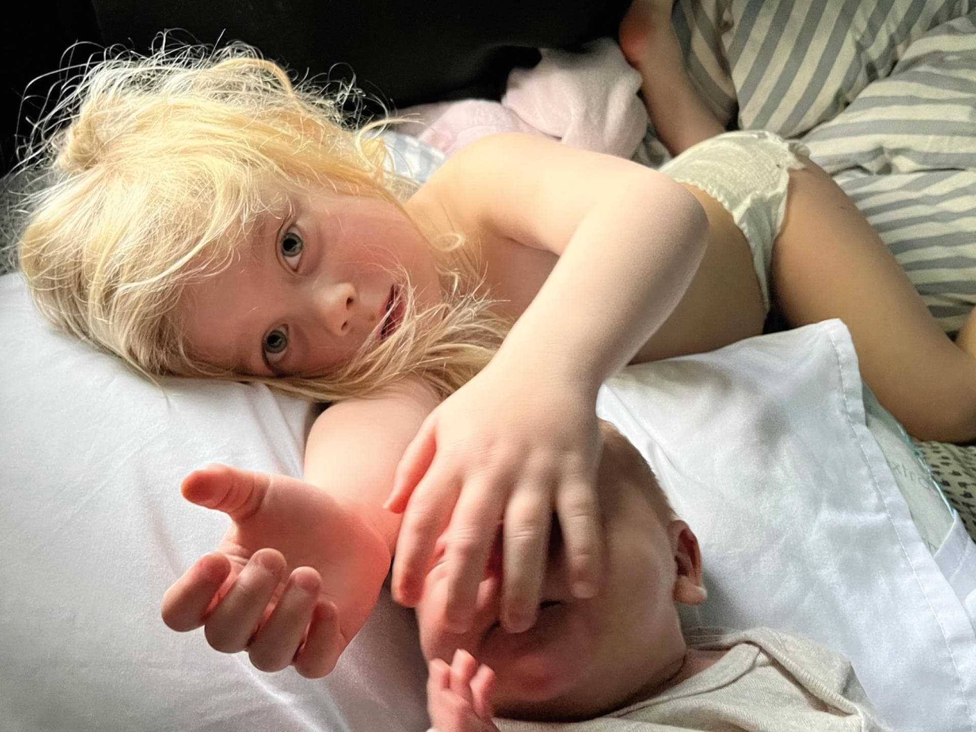 Zwei Geschwister liegen zusammen im Bett