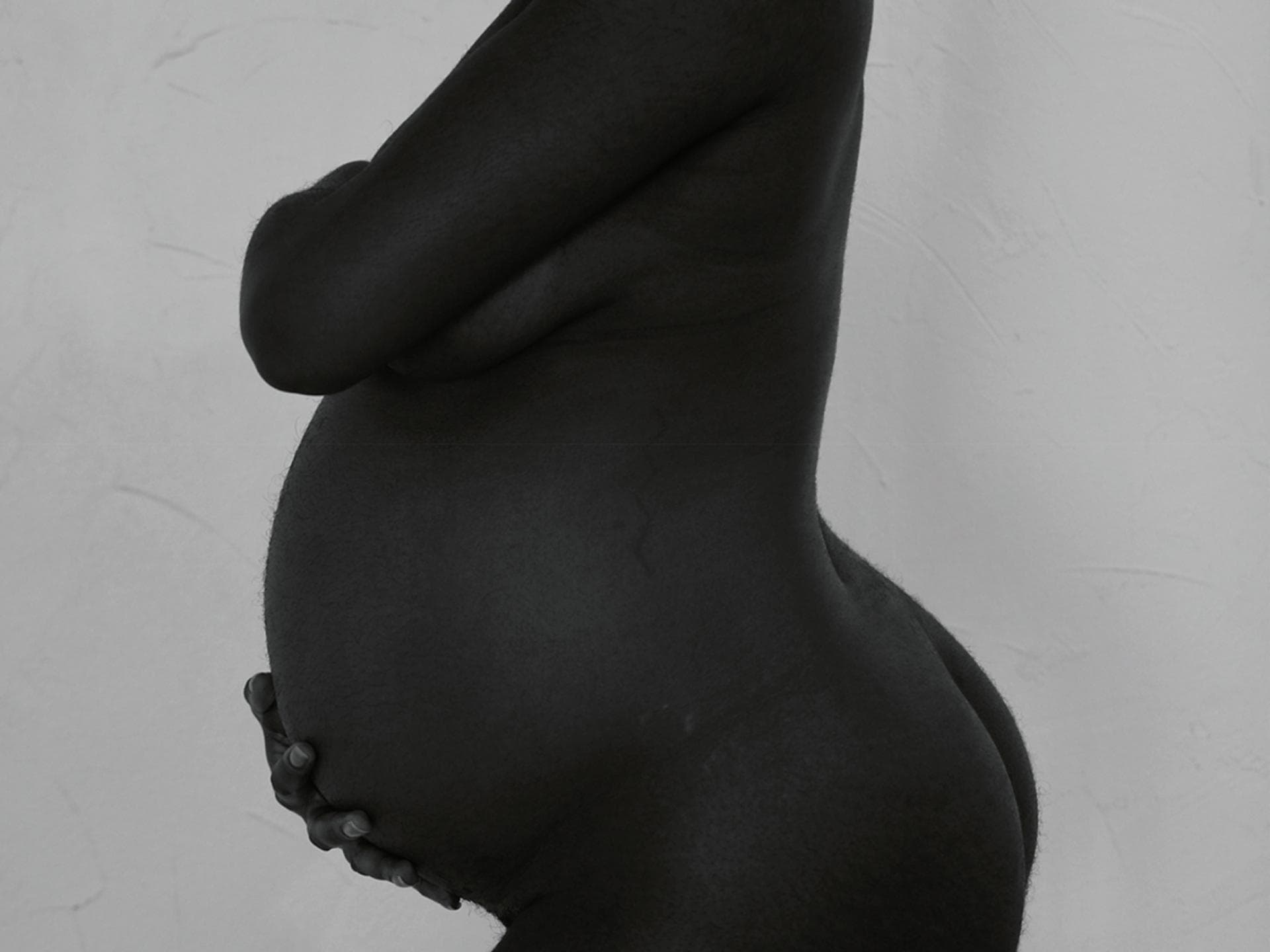 Die Silhouette einer nackten schwangeren Frau 