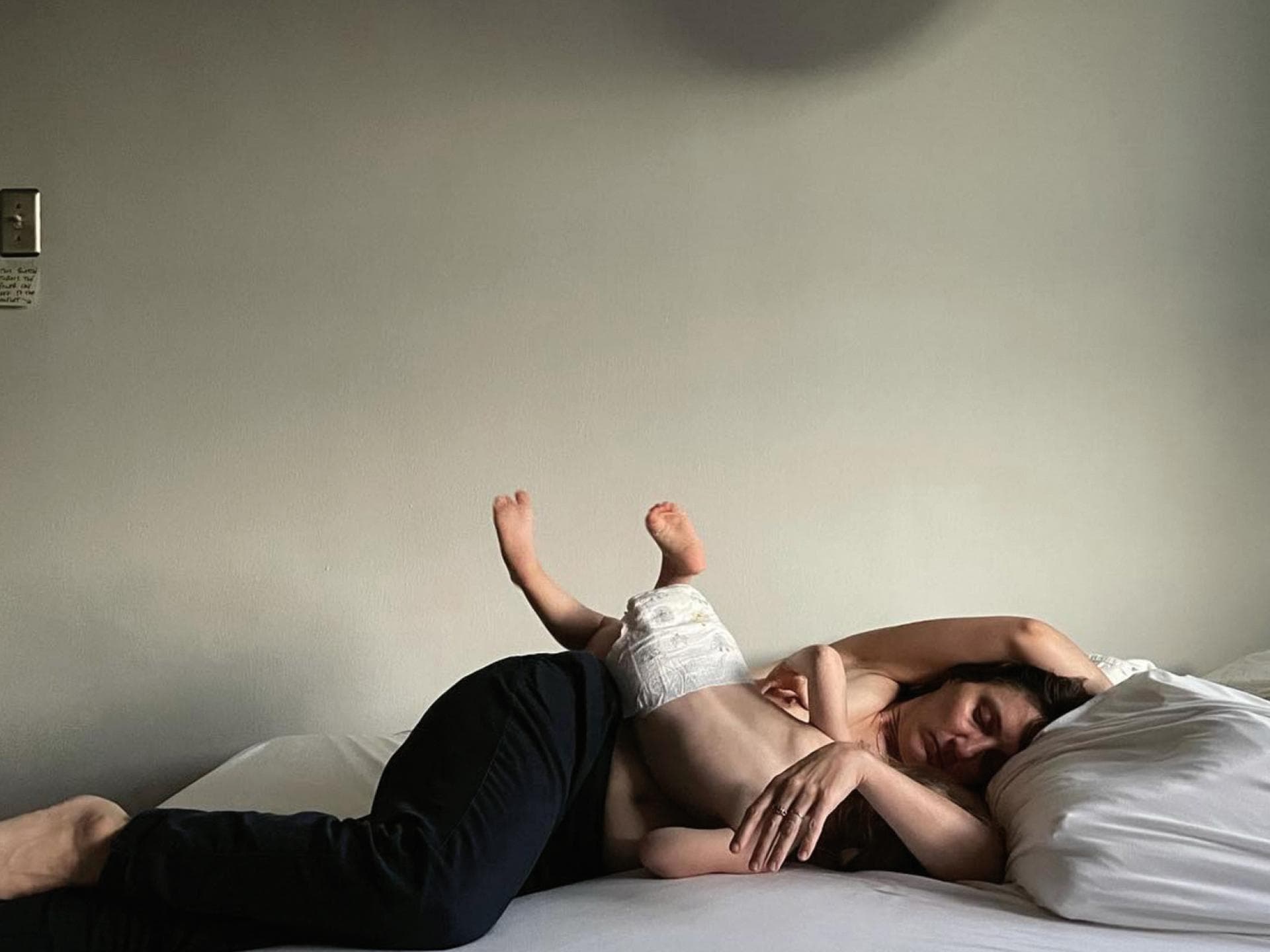 Eine stillende Frau mit Kleinkind im Bett