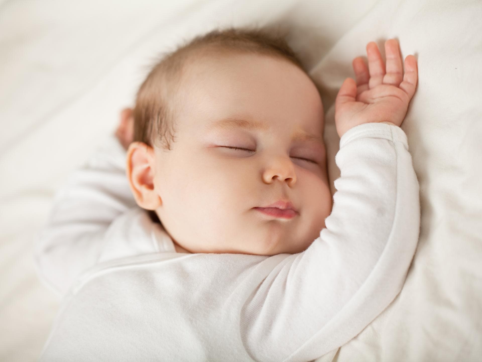 Mit ein paar Tricks lernt euer Baby, ruhig in seinem Bettchen zu schlafen. Ein Baby schläft in seinem Bett.