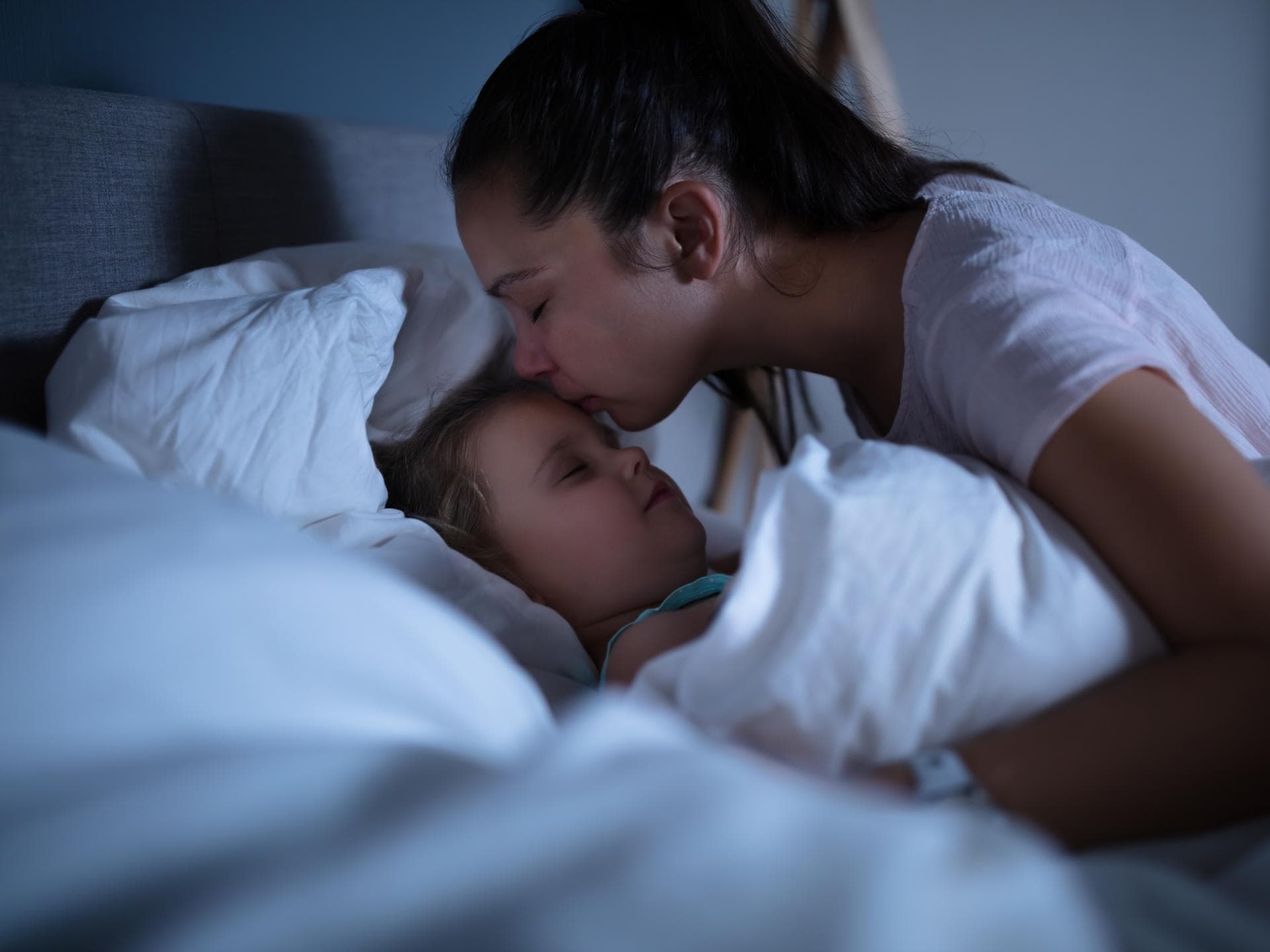 Mutter tröstet ihr Kind nach einem Nachtschreck Mutter tröstet ihr Kind nach einem Nachtschreck