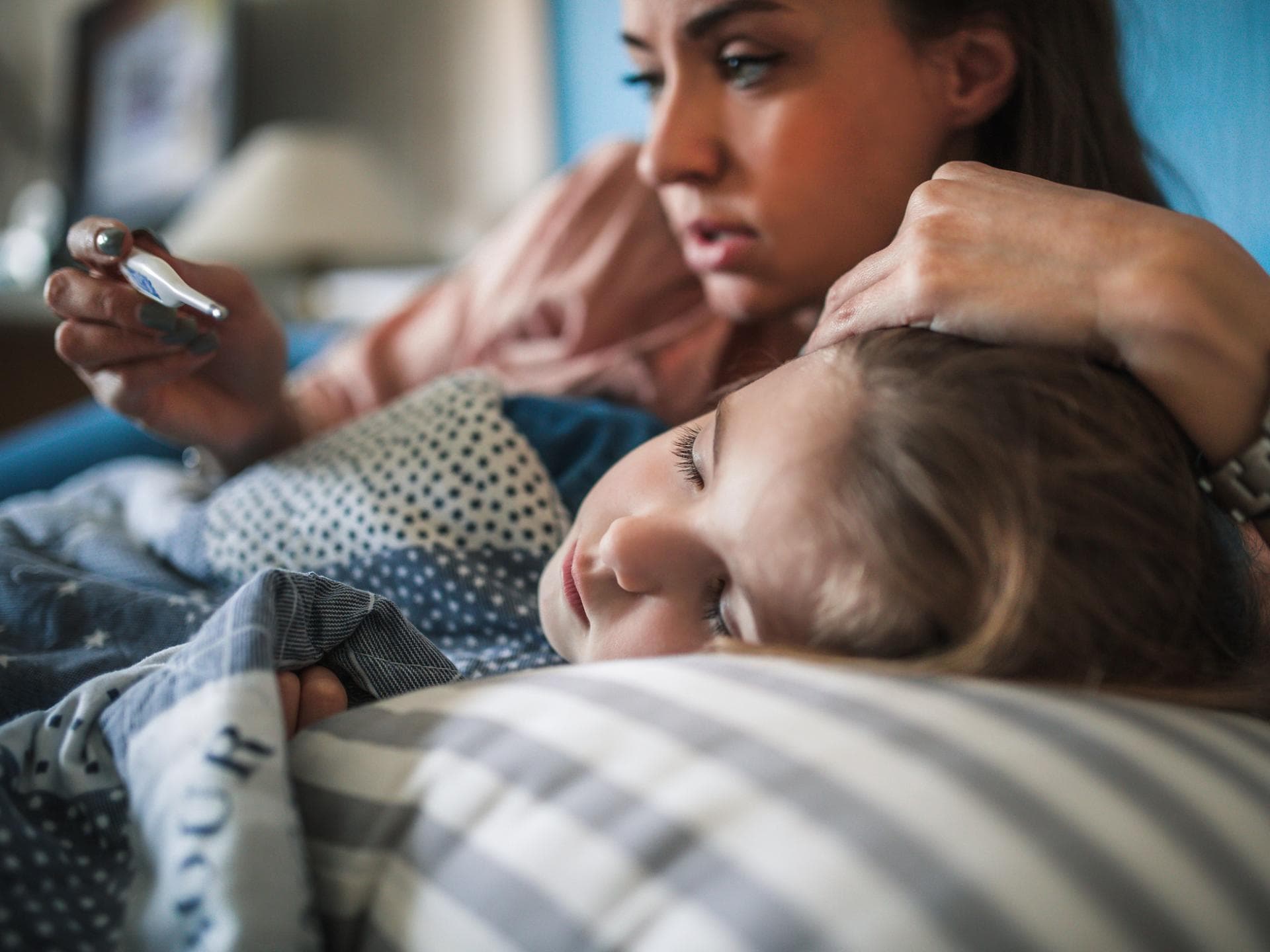 Mutter misst Fieber bei ihrer Tochter