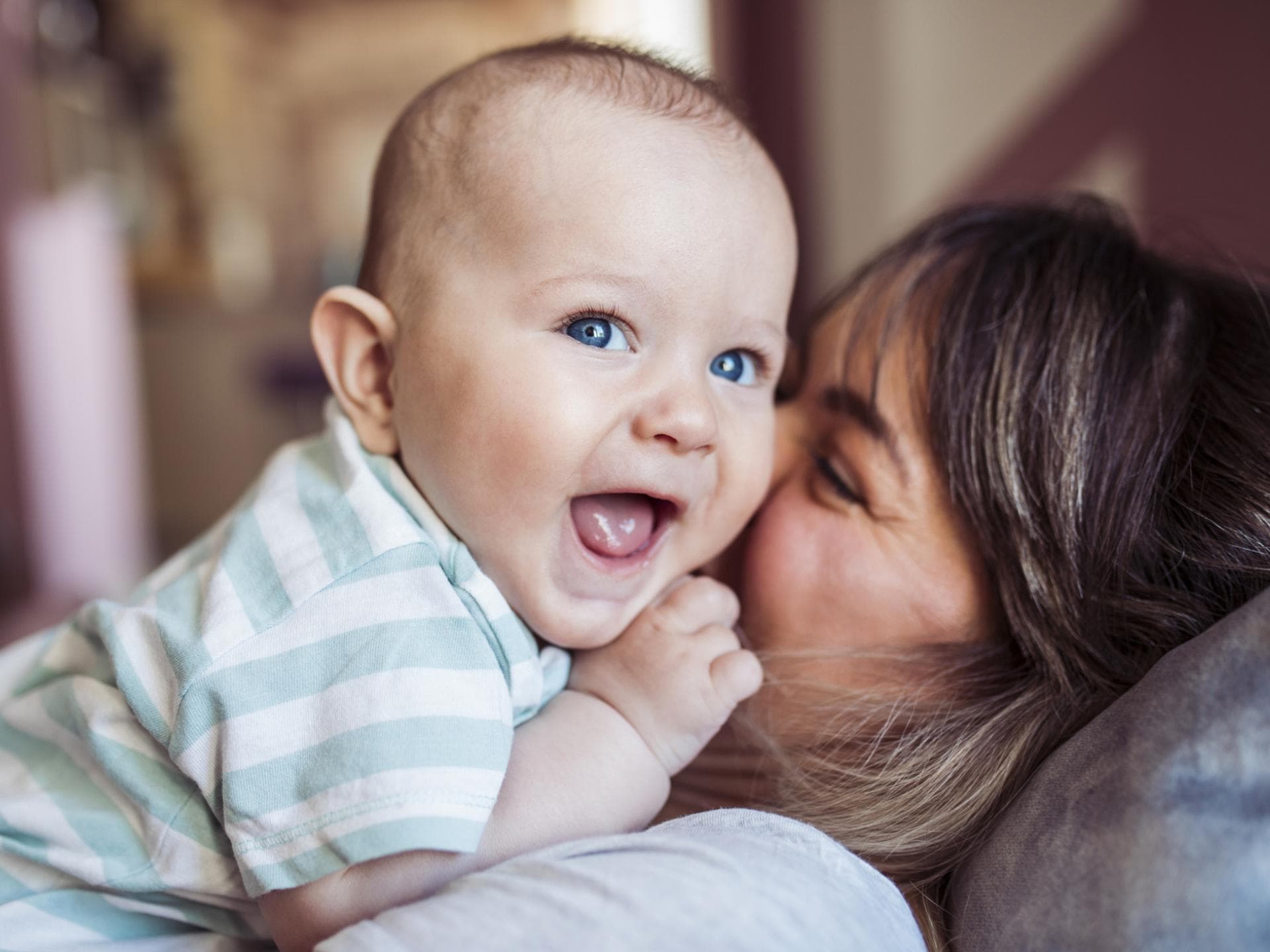 Mama küsst ihr lachendes Baby