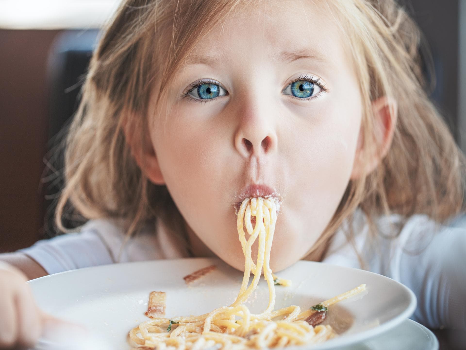 Kinder sollen Freude am Essen haben. Ein Mädchen isst Spaghetti.