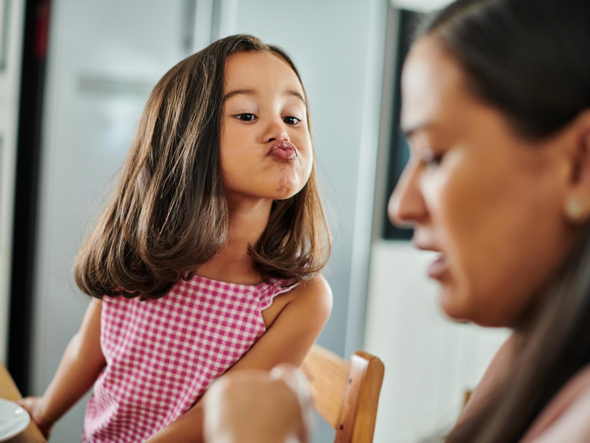 Wenn fremde Kinder anderen Eltern gegenüber zu körperlich werden, kann es schwierig werden. Ein kleines Mädchen macht einen Kussmund und die Erwachsene reagiert nicht darauf
