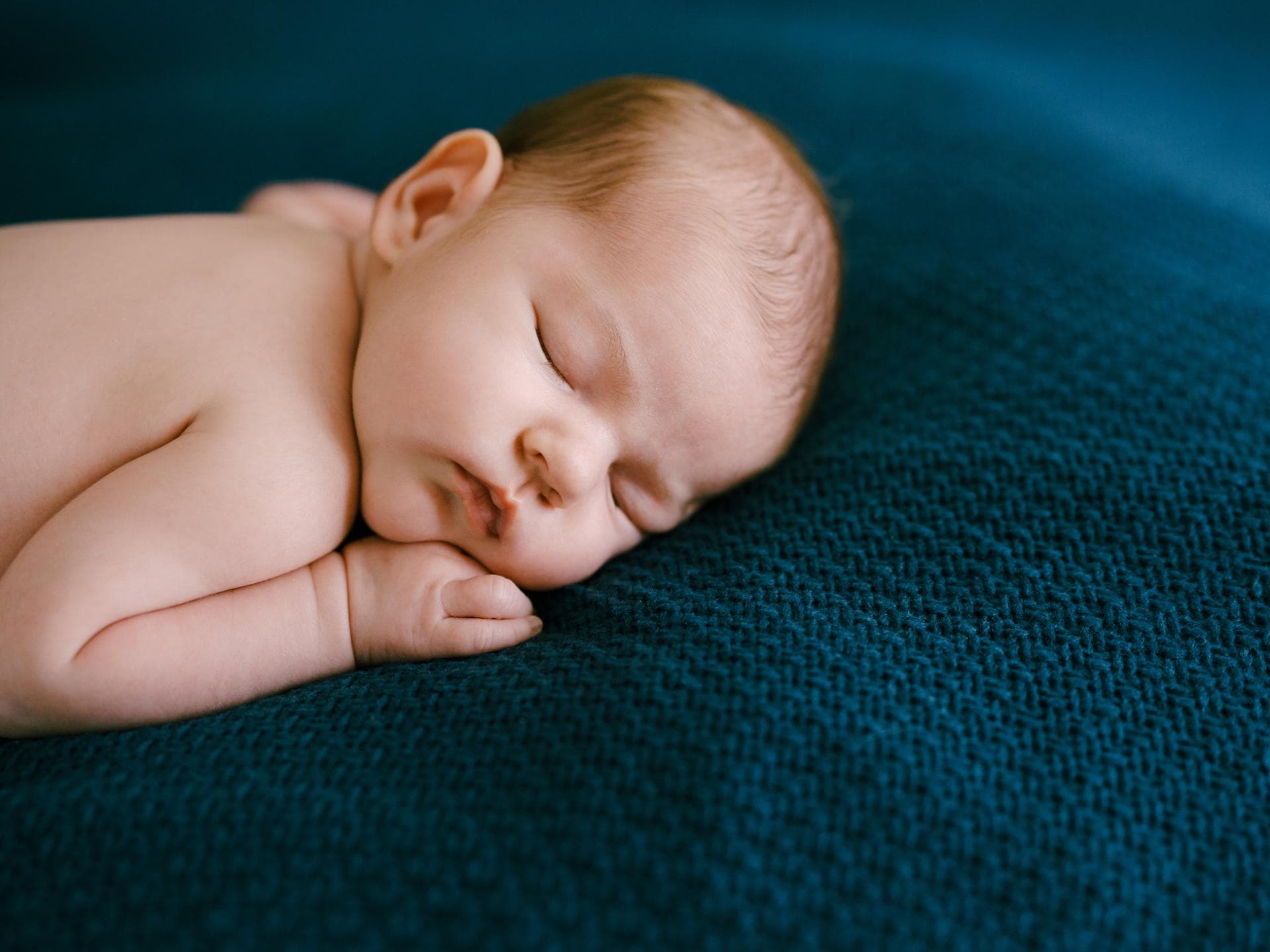 Wenn sich das Baby nachts auf den Bauch dreht, sorgen sich viele Eltern. Ein Baby schläft in Bauchlage.