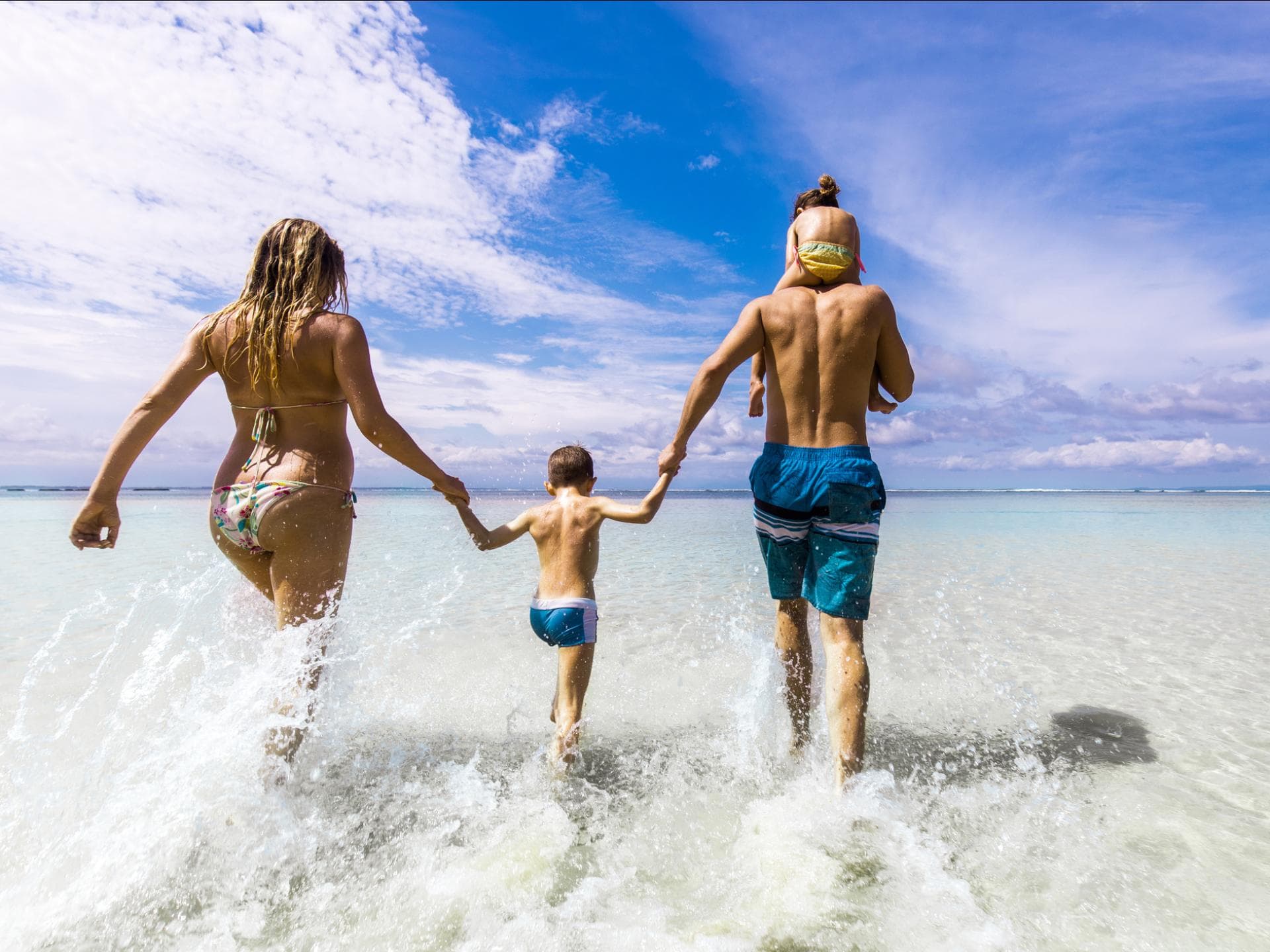 Eine Familie läuft ins Meer.