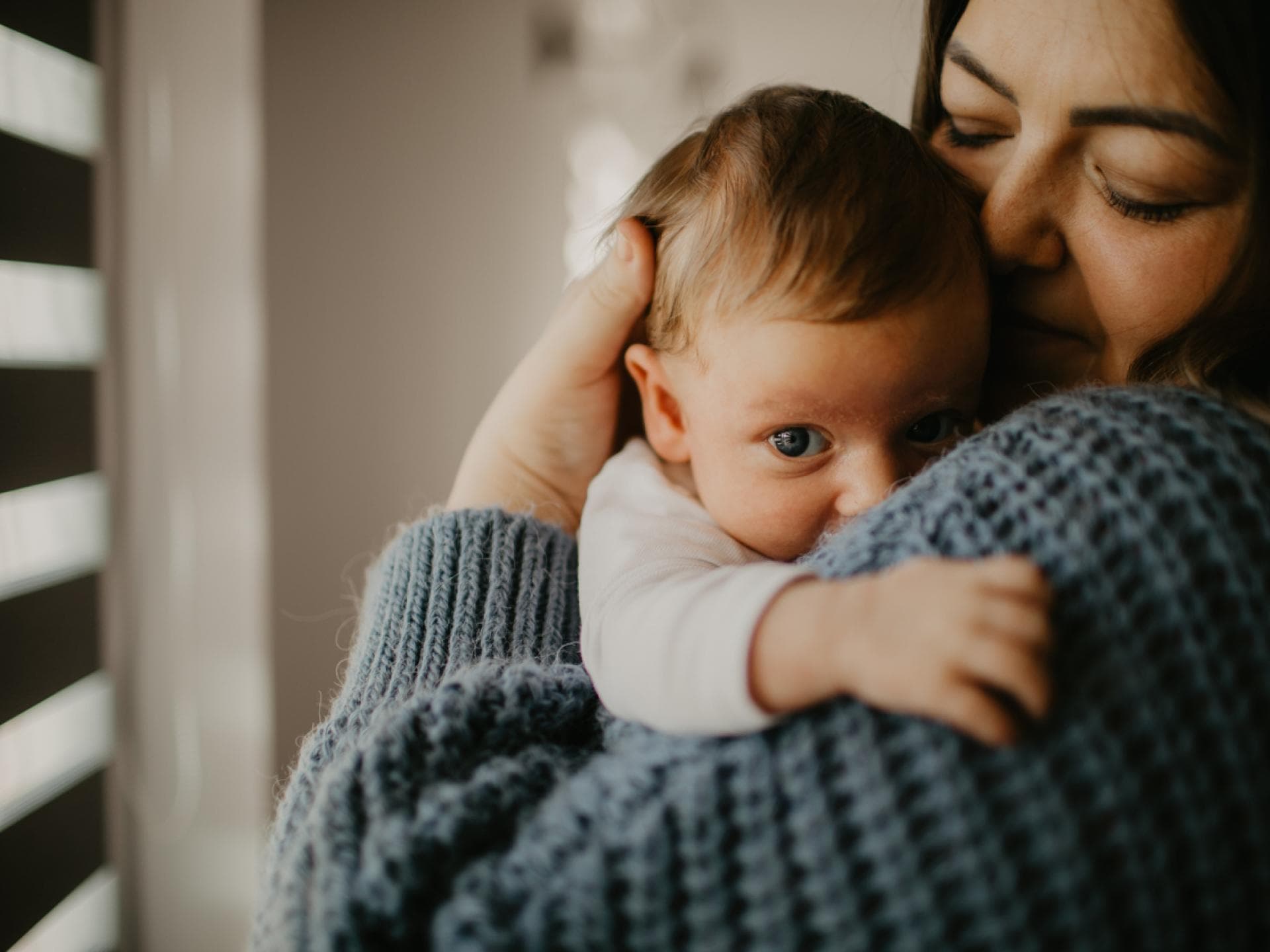 Neugeborener Junge auf dem Arm seiner Mama