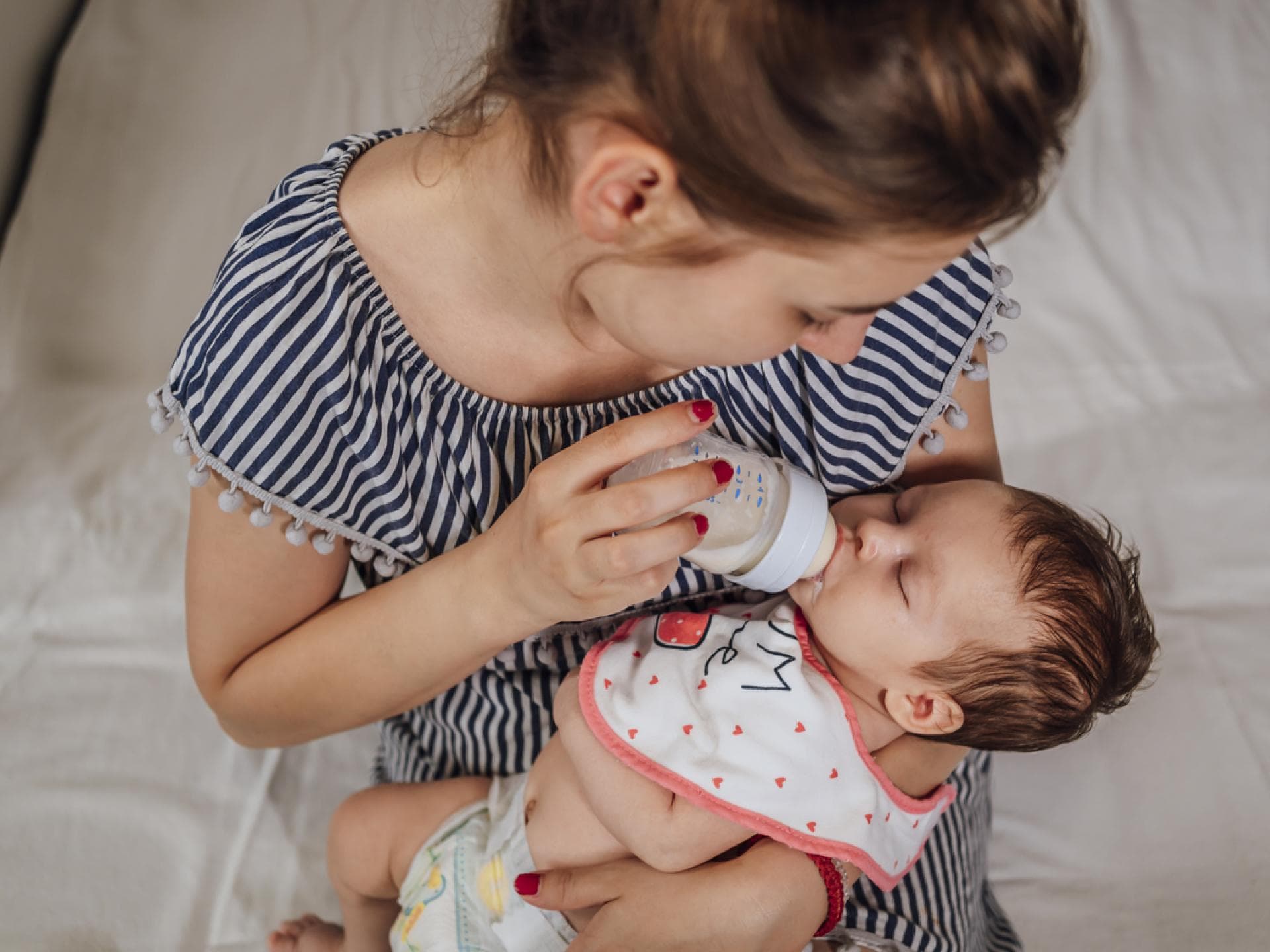 Eine junge Frau füttert ihr Baby mit der Flasche