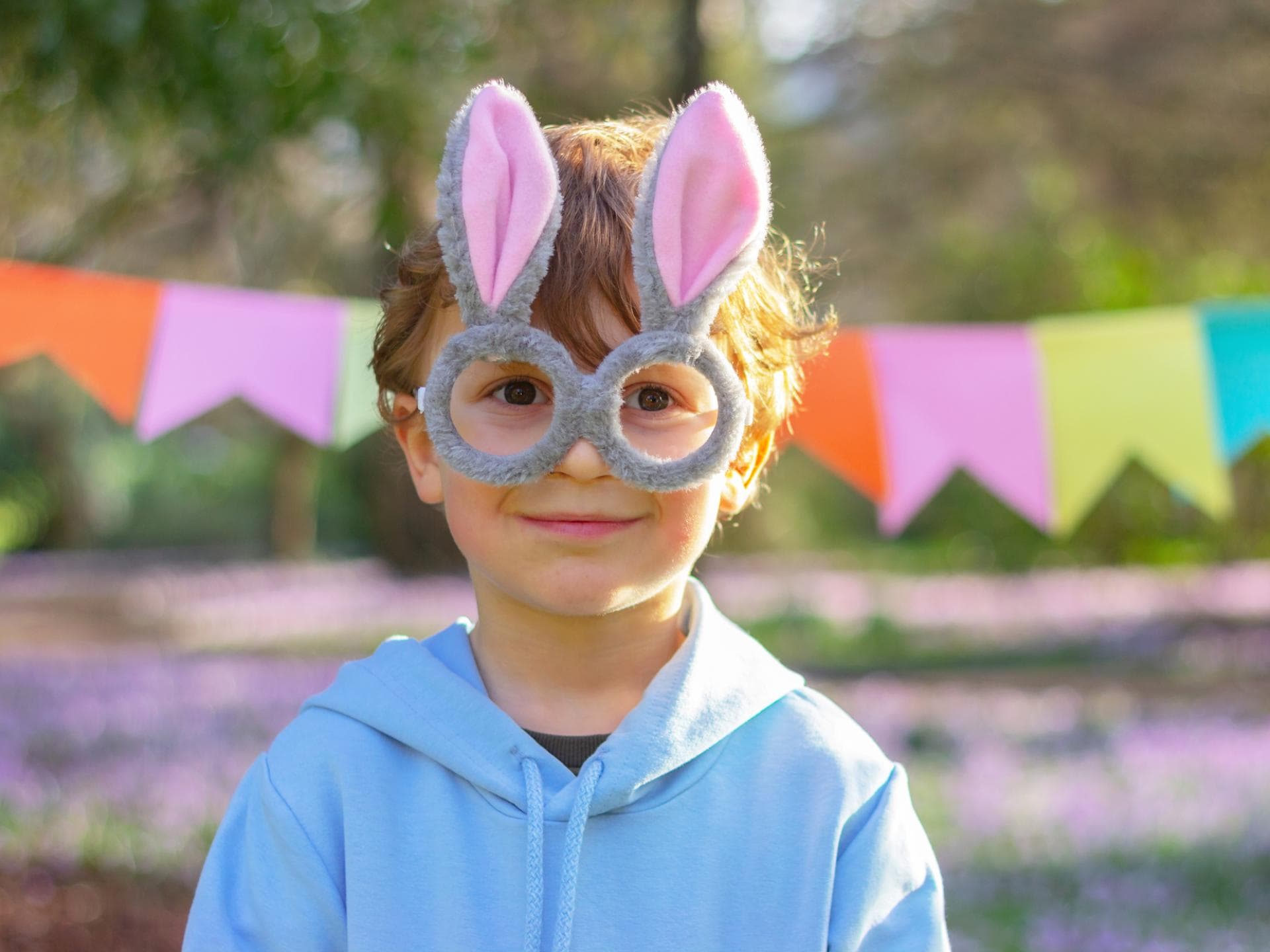 "Wie, den Osterhasen gibt es nicht!?" Ein kleiner Junge mit einer Osterhasen-Brille.