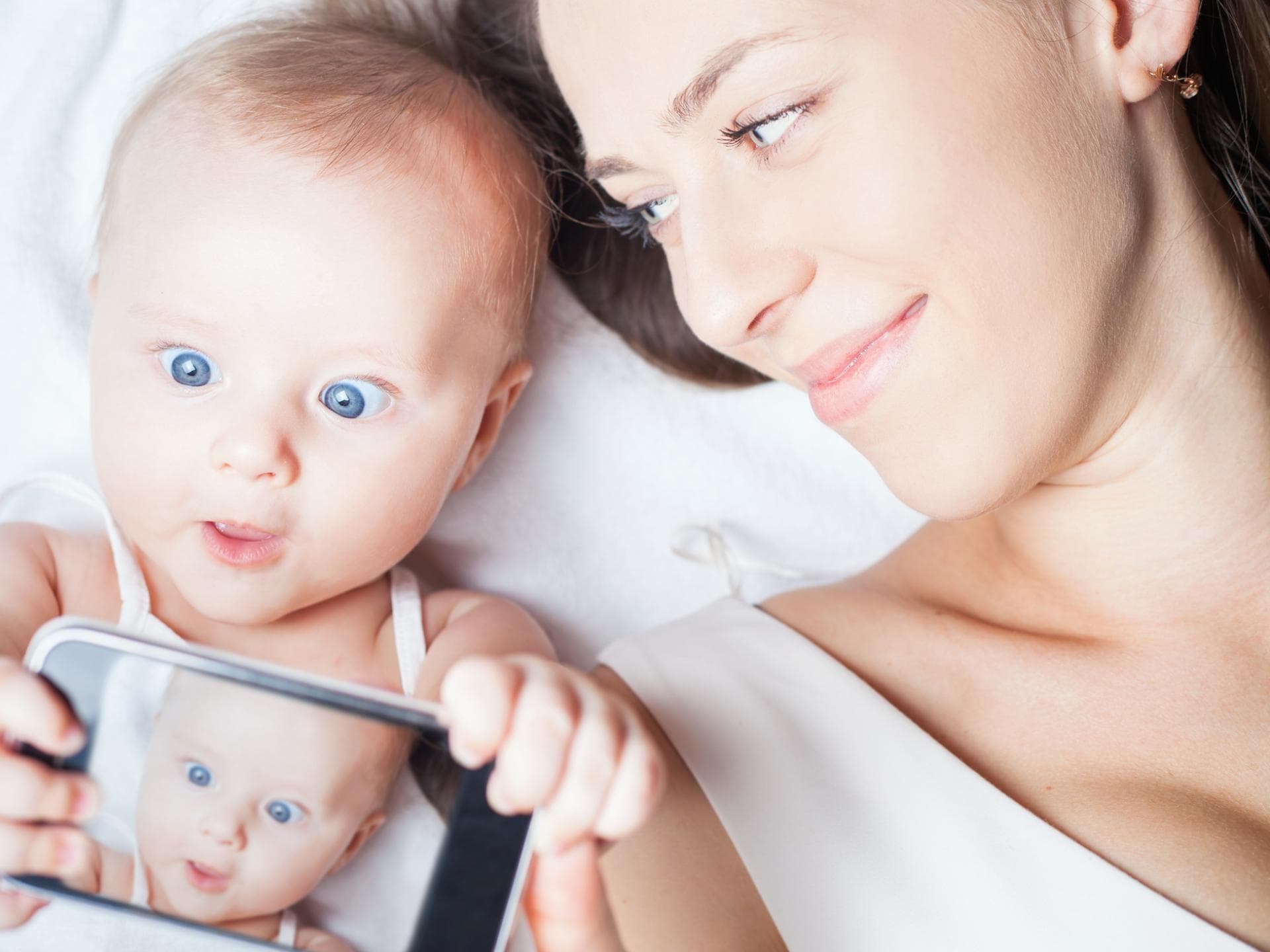 Videoanrufe sind für Kinder oft ein großer Spaß. Baby hält Handy in der Hand