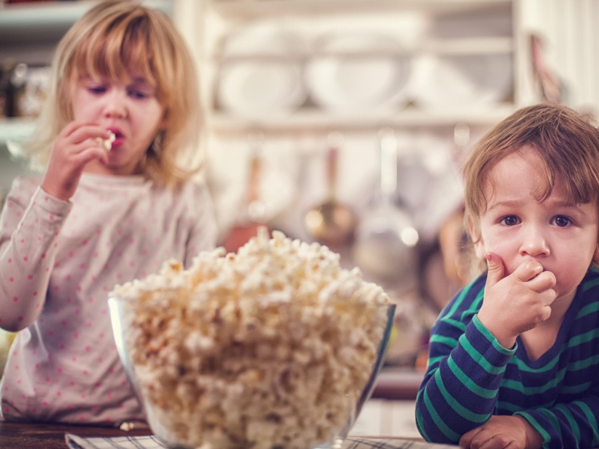 Zwei kleine Kinder essen Popcorn 