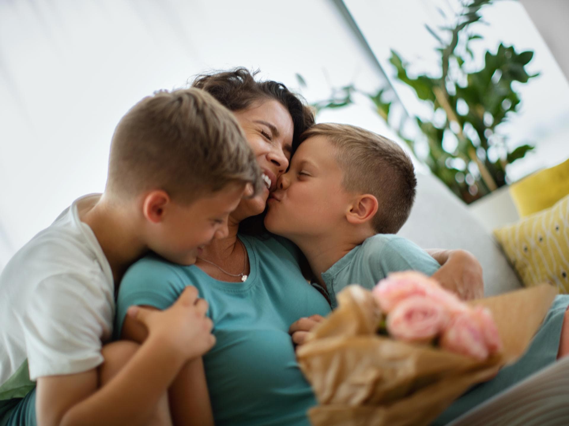 Mama freut sich über einen schönen Spruch zum Muttertag. Zwei Jungs gratulieren ihrer Mama zum Muttertag