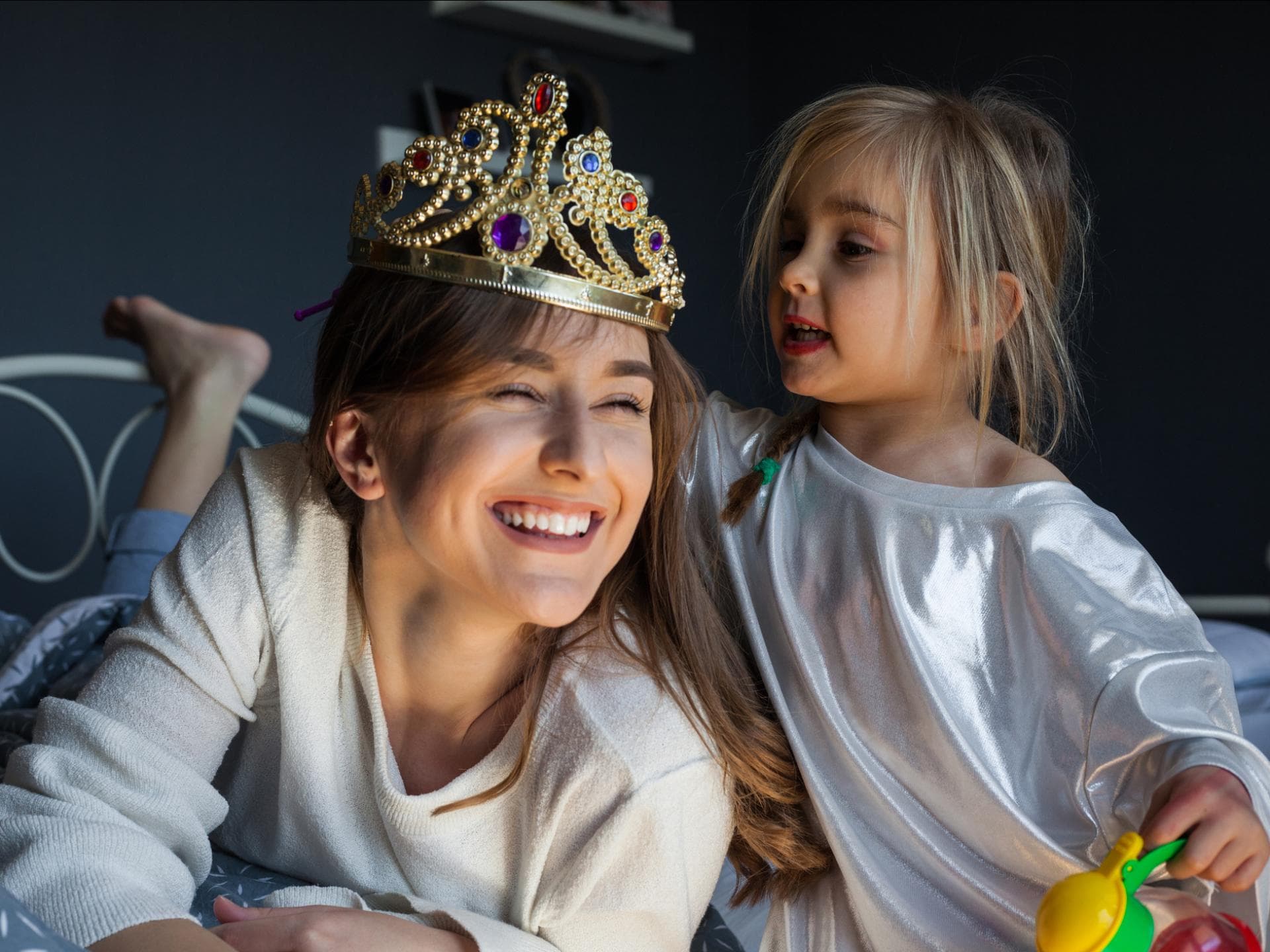 Kleines Mädchen setzt der Mutter eine Krone auf
