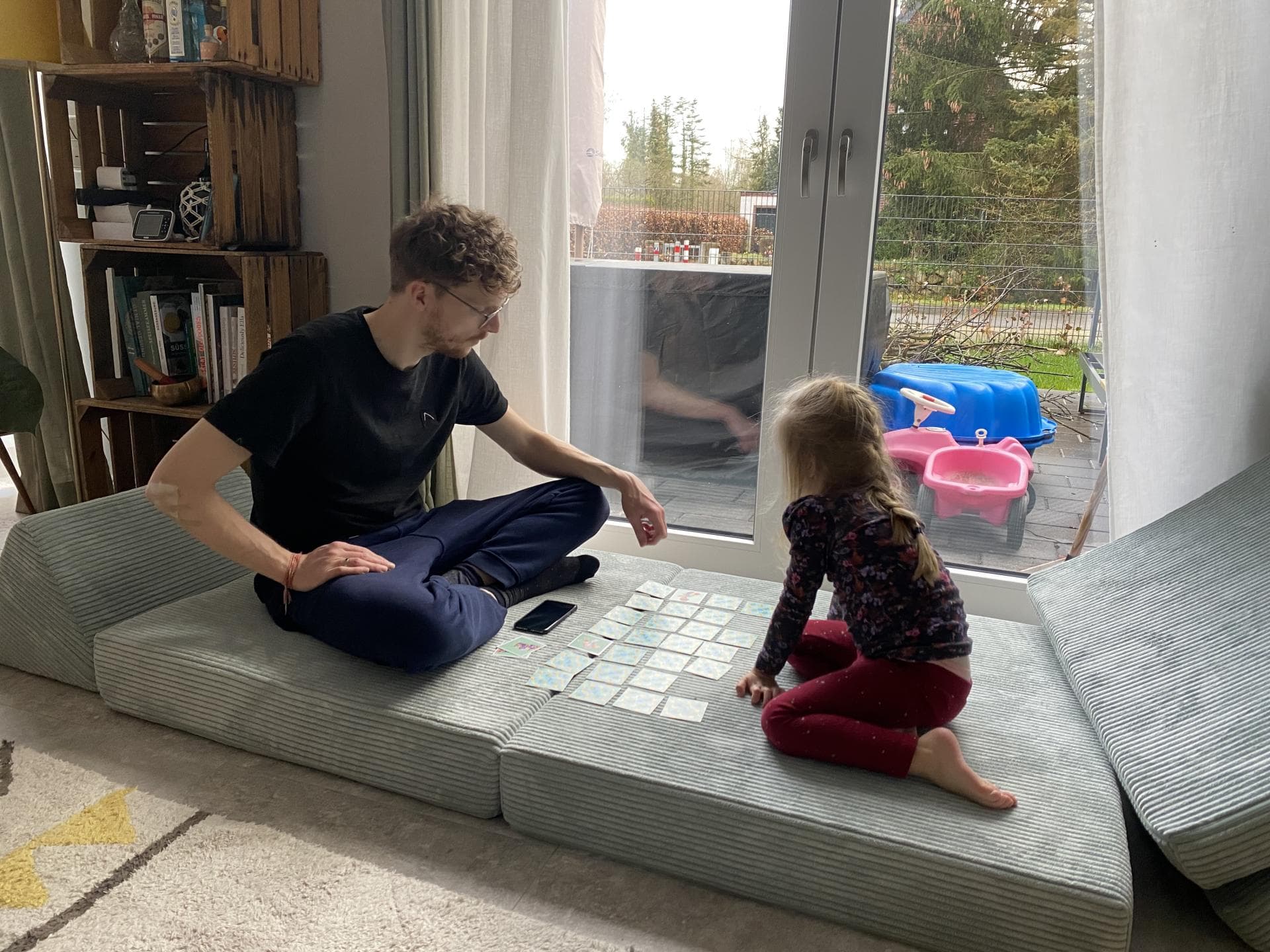 Papa und Tochter spielen Memory auf einem Spielsofa Papa und Tochter spielen Memory auf einem Spielsofa