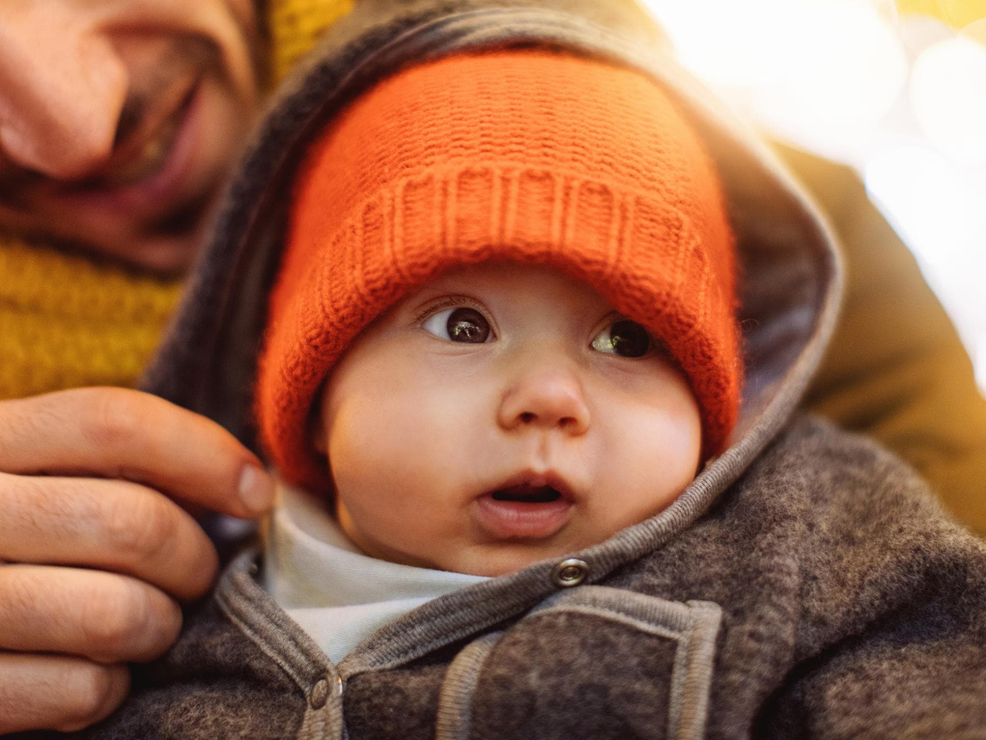 Ein Vater hält sein Baby im Arm. 
