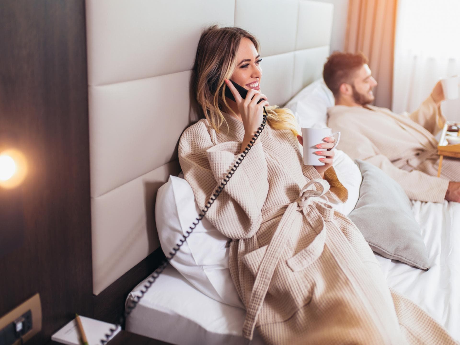 Ein Pärchen genießt den Roomservice im Hotelbett