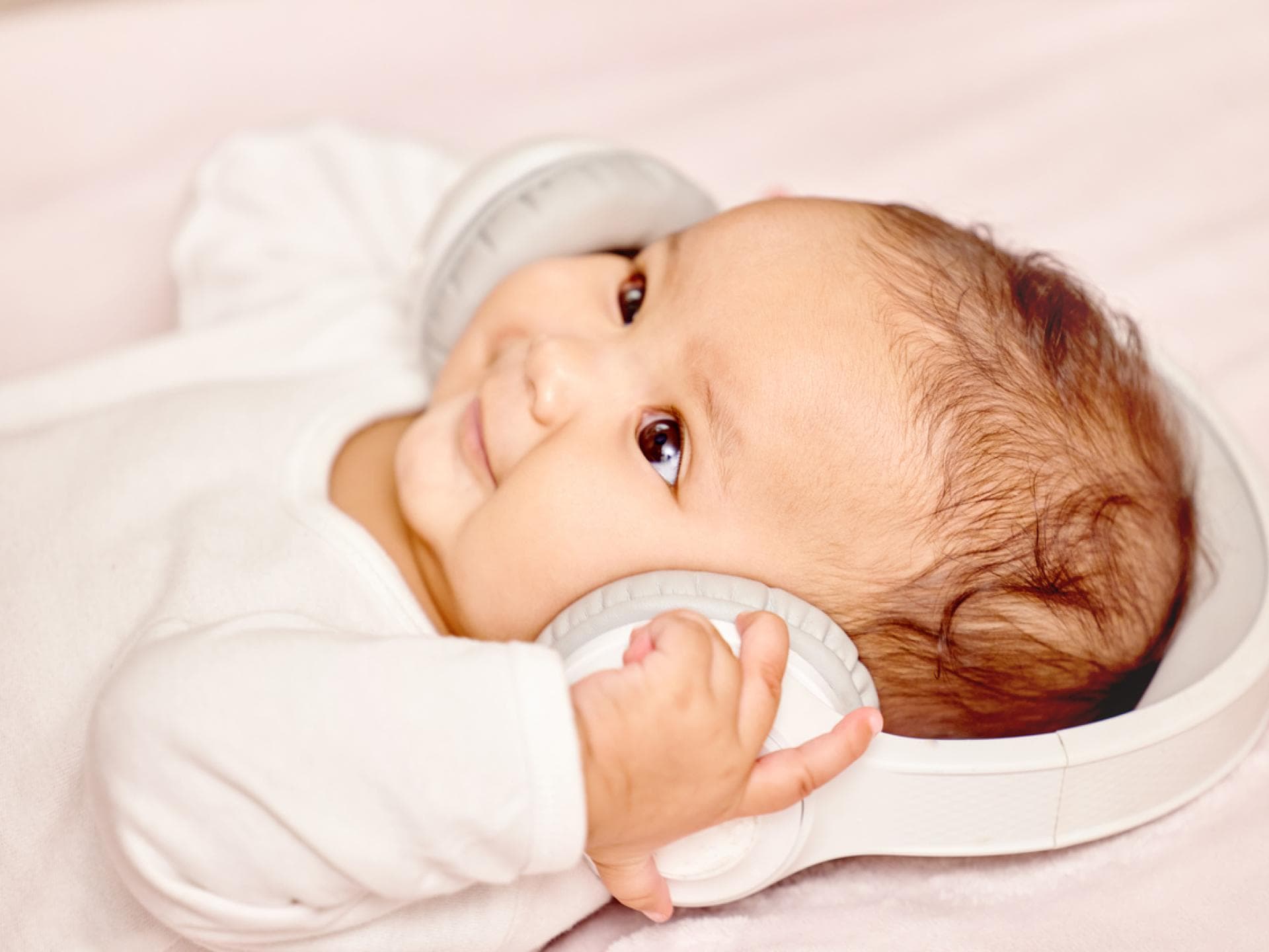 Ein Baby hat Kopfhörer auf den Ohren. 