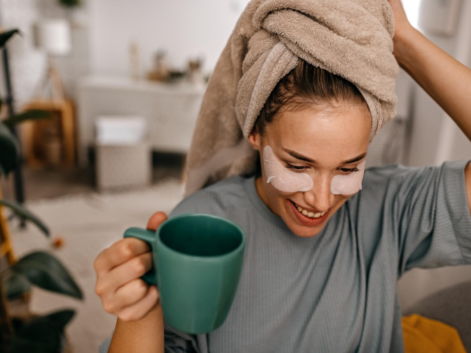 Frau mit Augenpads trinkt Kaffe zu Hause und lässt sich treiben