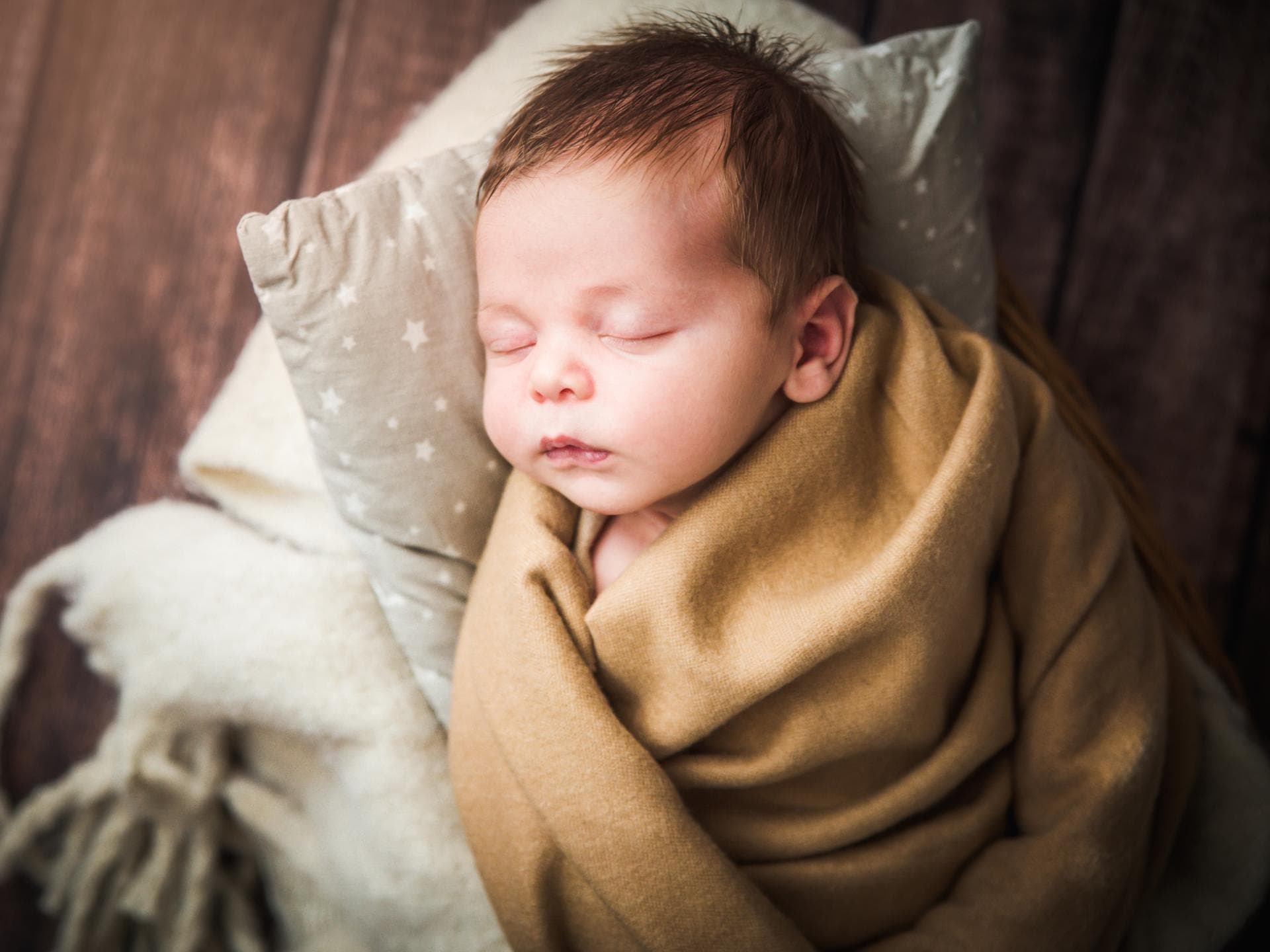 Mädchennamen mit Y sind etwas ganz Besonderes. Ein Baby liegt in Decken eingewickelt und schläft.