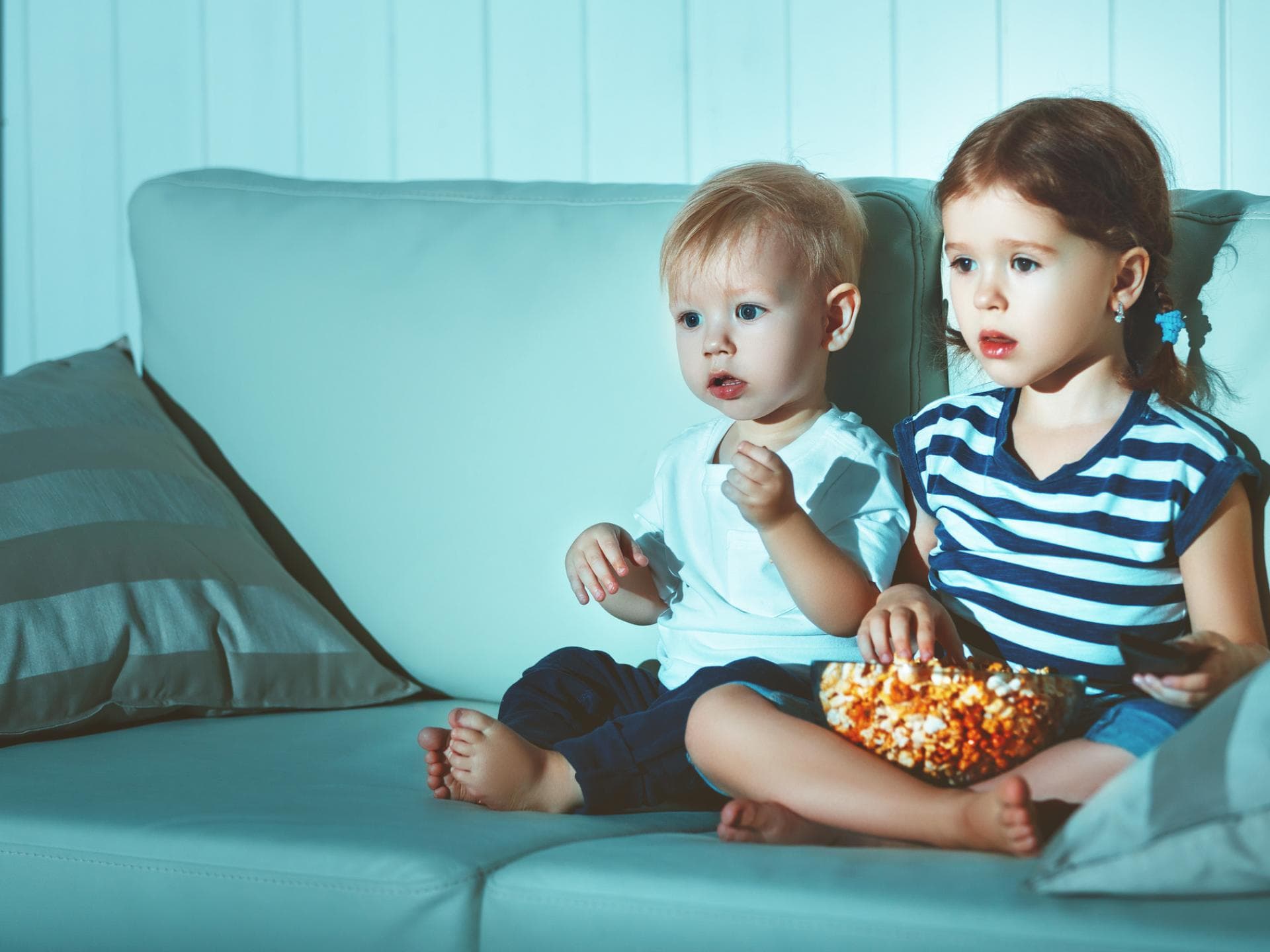 Zwei Kinder sitzen auf dem Sofa