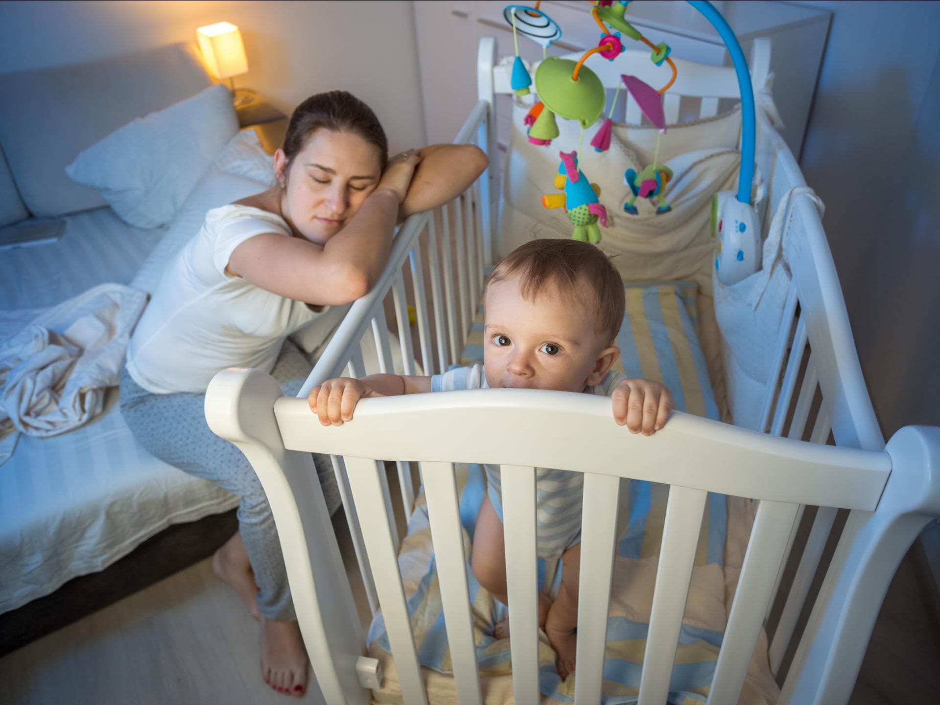 Baby steht nachts wach im Bett. Baby steht nachts wach im Bett.