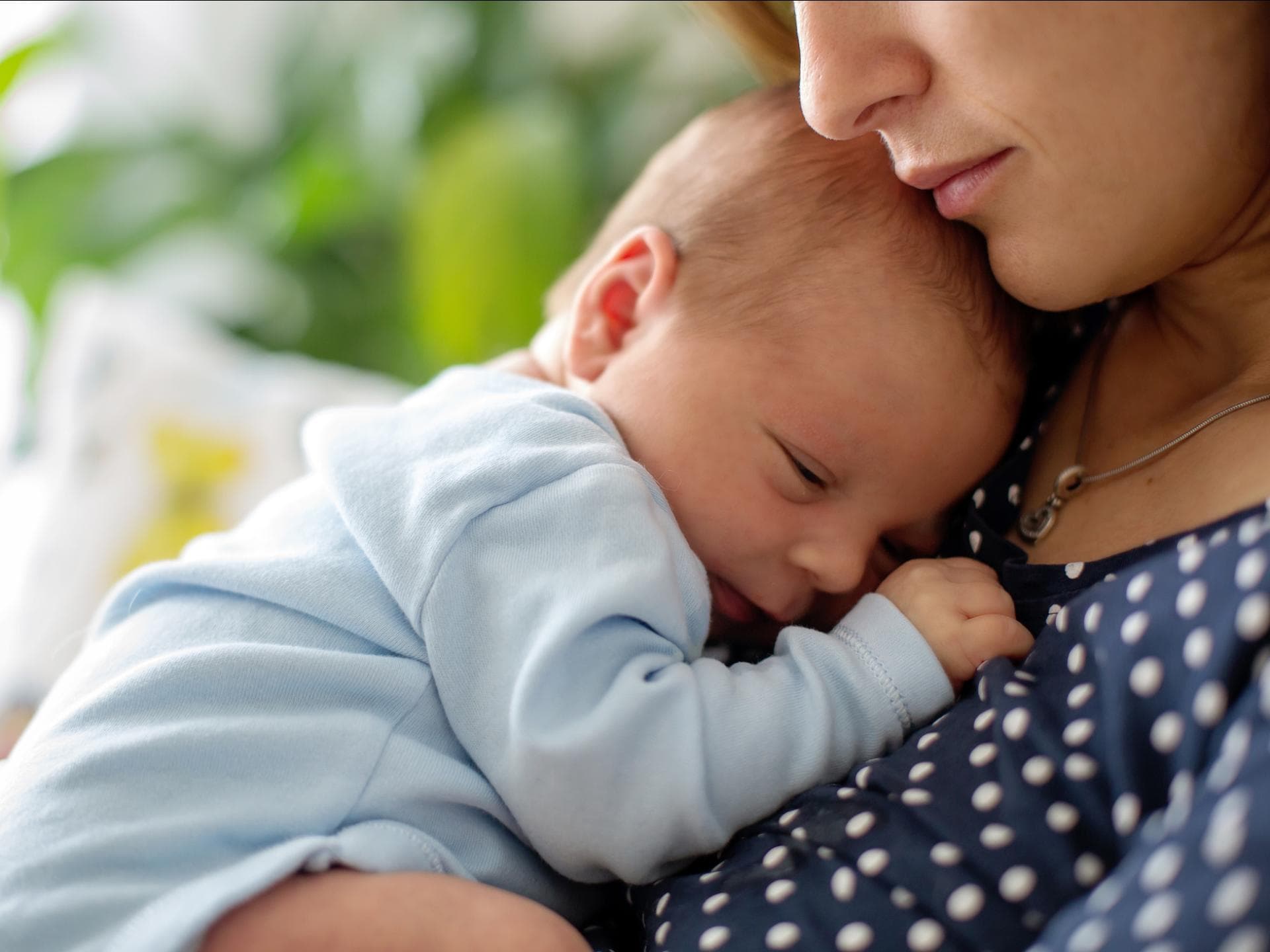 Baby liegt auf Mamas Brust.