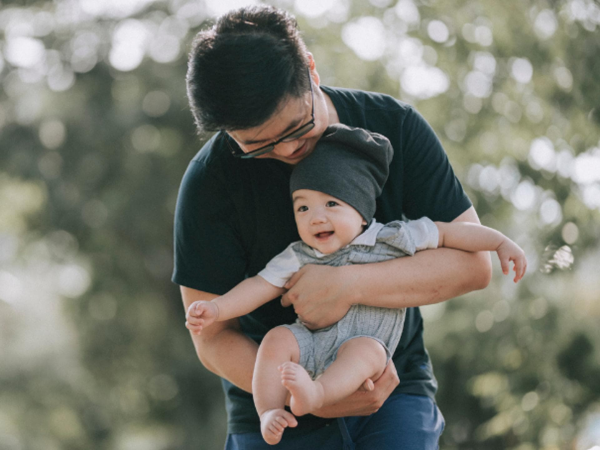 Ein asiatischer Vater trägt seinen Baby-Jungen auf dem Arm. Ein asiatischer Vater trägt seinen Baby-Jungen auf dem Arm.