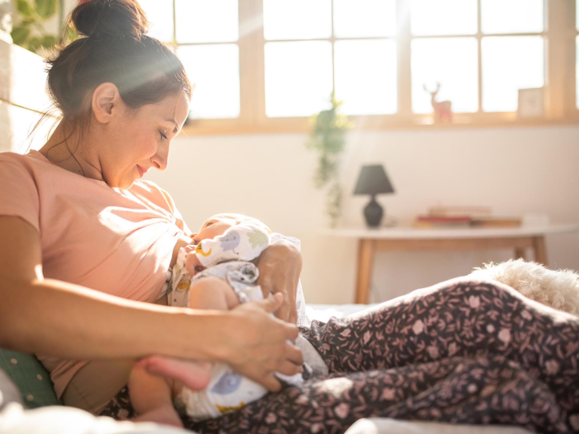 Dauernuckeln: Junge Mutter hält ihr Baby in den Armen zum Stillen und Nuckeln. Dauernuckeln: Junge Mutter hält ihr Baby in den Armen zum Stillen und Nuckeln.