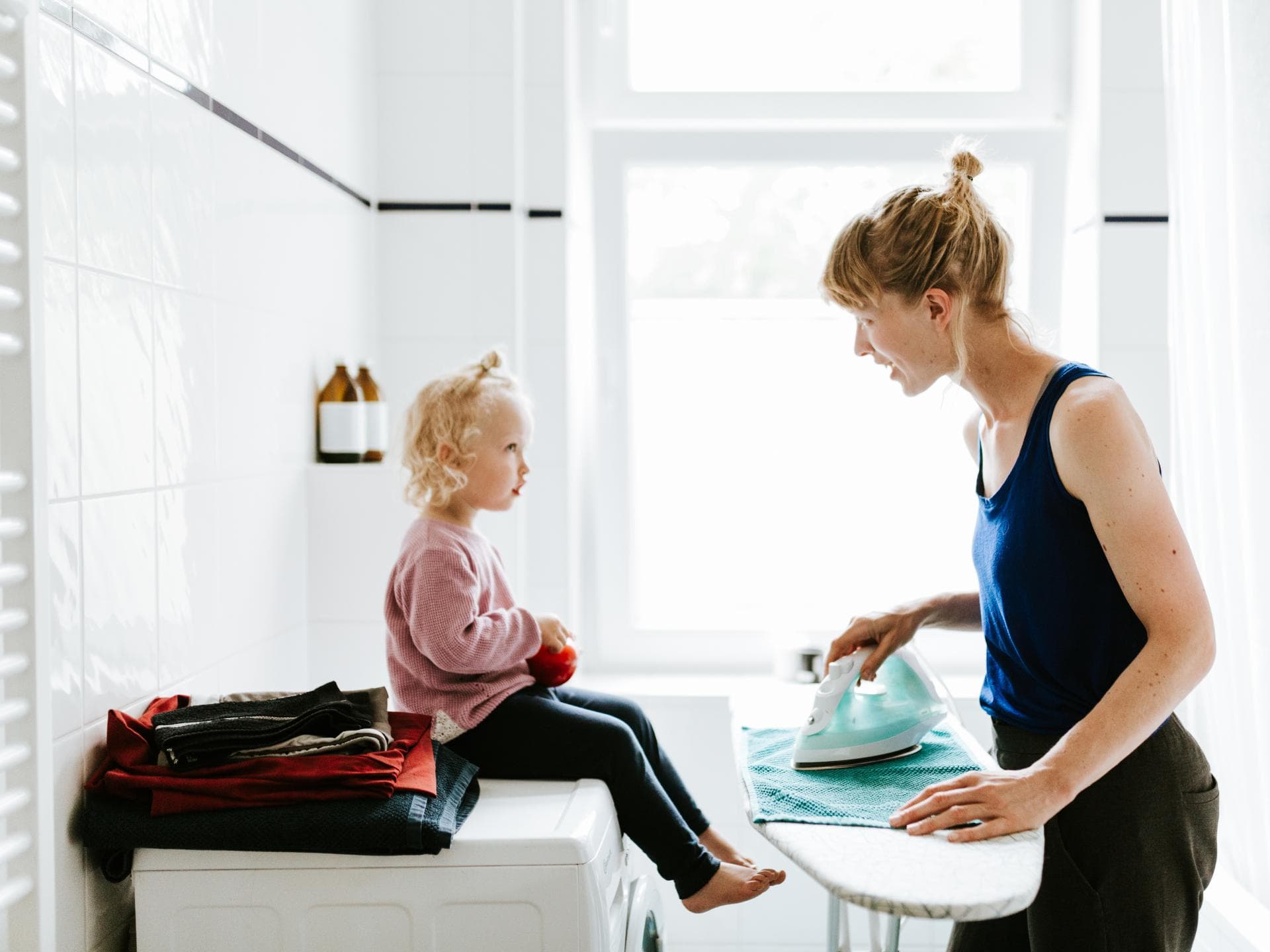 Mutter bügelt und spricht mit Tochter. Mutter bügelt und spricht mit Tochter.