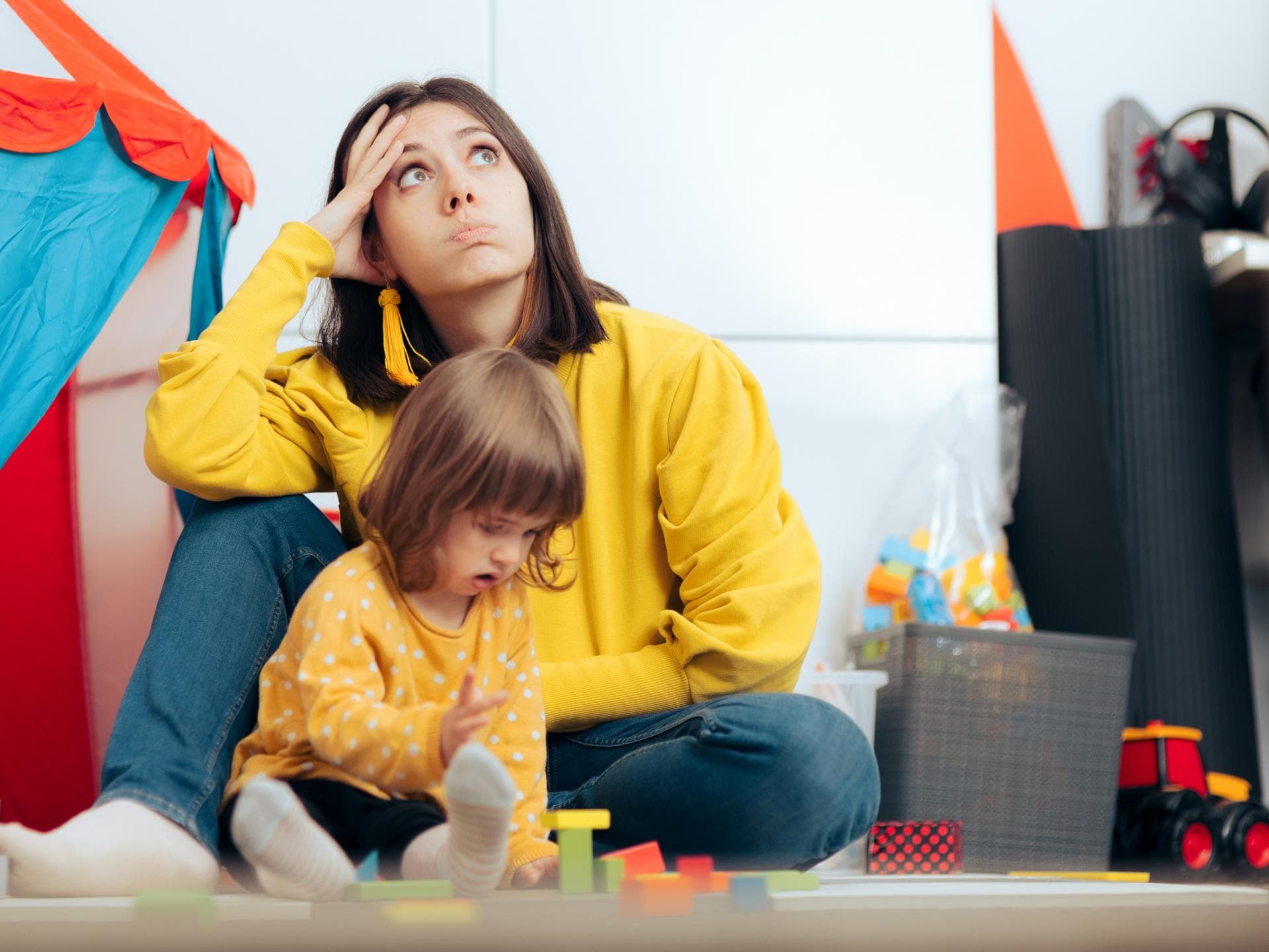 Genervte Mutter mit spielender Tochter.