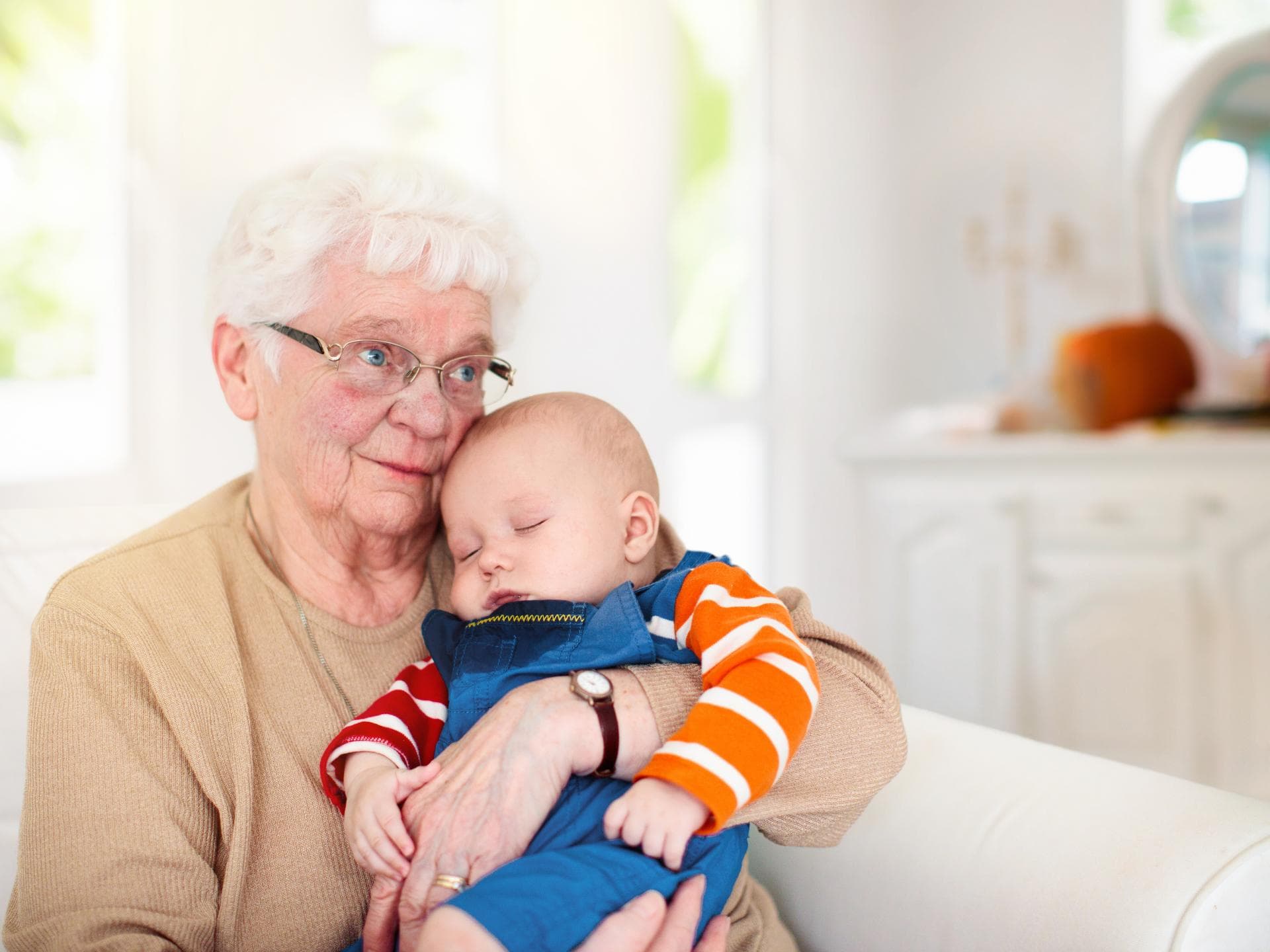Oma hält schlafendes Baby im Arm. Oma hält schlafendes Baby im Arm.