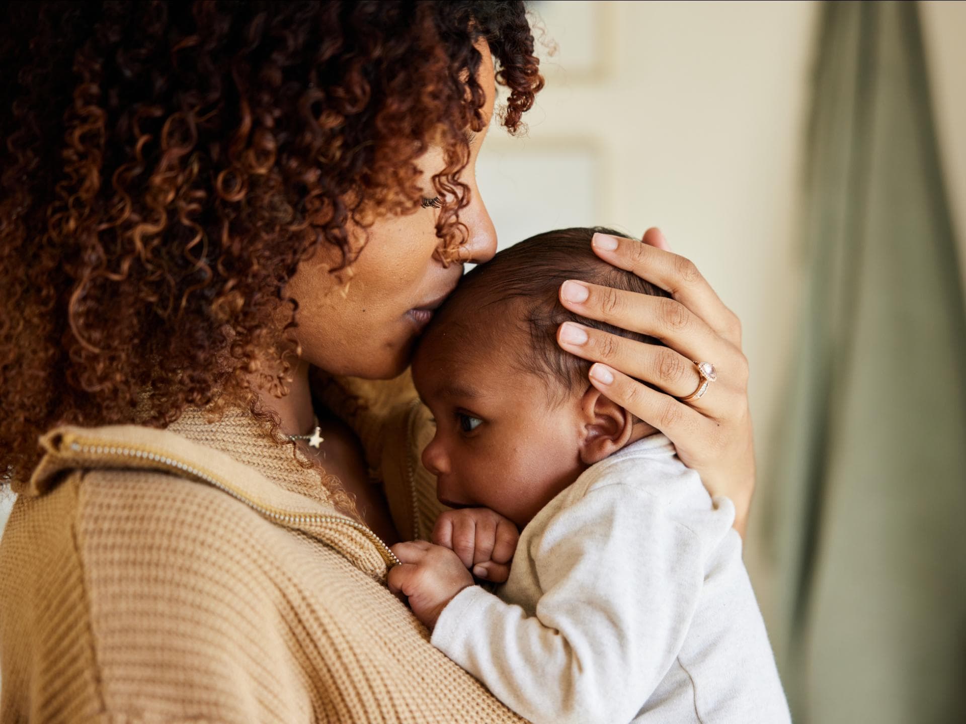 Deutsche Vornamen in den USA immer beliebter. Mutter küsst ihr Baby.